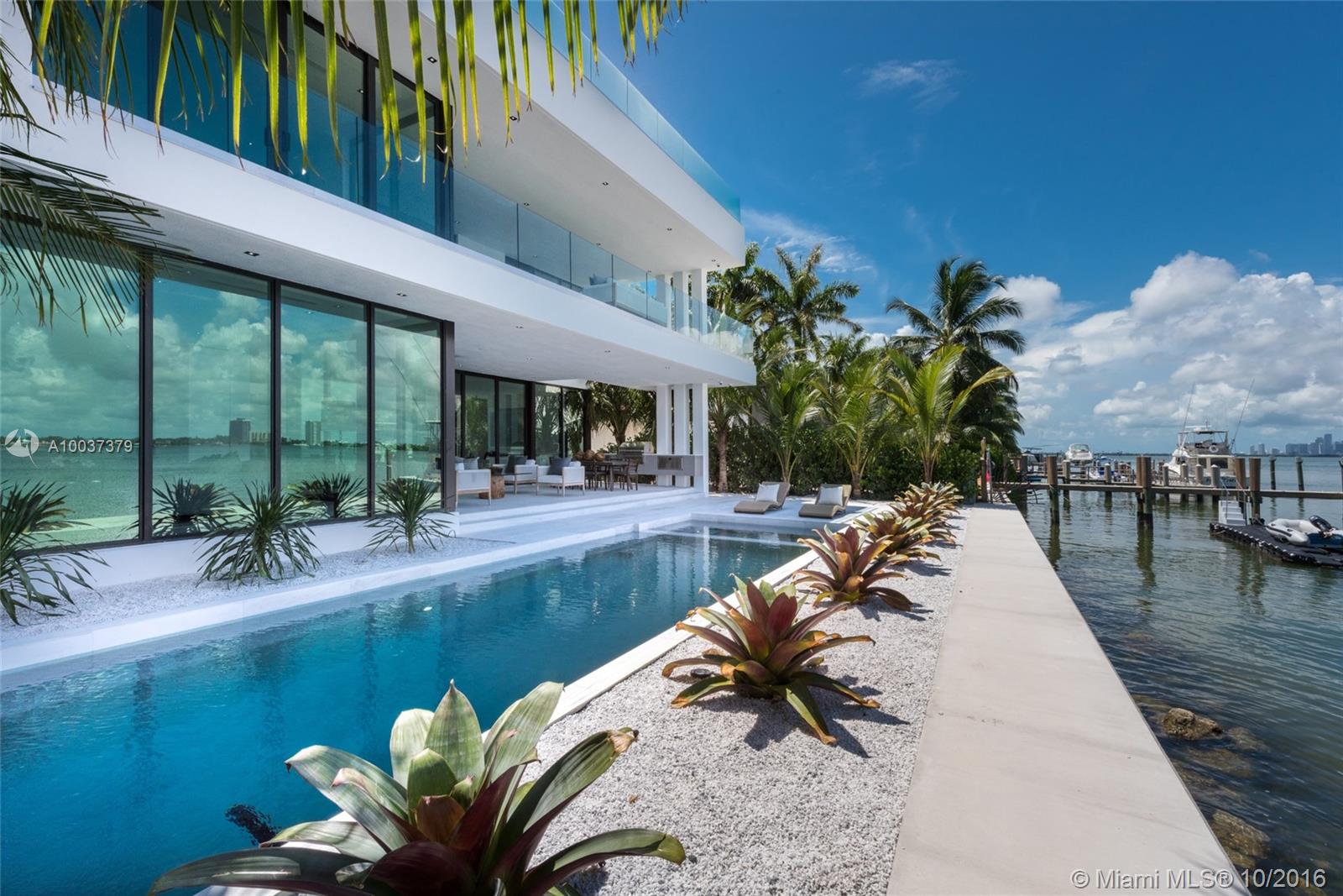 New modern masterpiece w/70ft of waterfront & breathtaking Miami skyline & open bay views. Designed by architect Jose Sanchez & built w/utmost attention to every detail using highest quality materials & finishes: glass enclosed large living rm, Poliform kitchen & closets, Sub-Zero/Wolf appliances, Calacatta marble & wood floors, frameless Italian doors. Large master suite w/direct Miami skyline views. Exterior: dock, rooftop terrace, deck w/ pool, spa & summer kitchen & 2car garage.