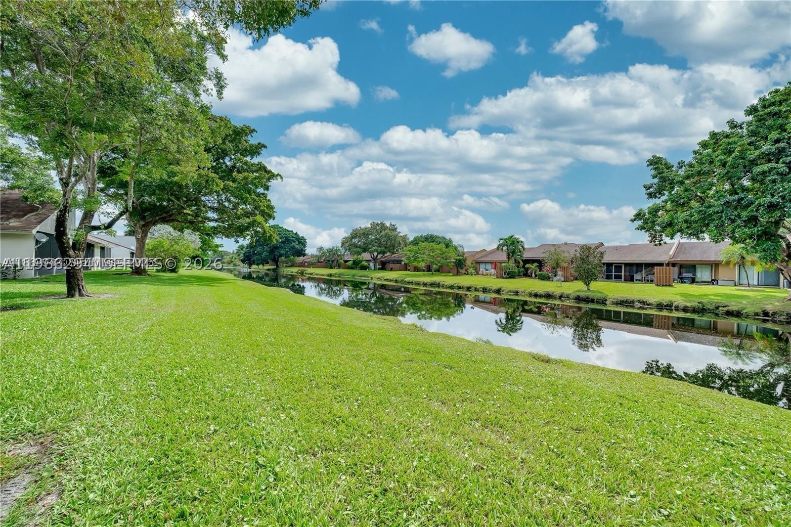 BEST VALUE LAKEFRONT VILLA IN ALPINE WOODS OF JACARANDA! LOWEST PRICED 2/2 CURRENTLY AVAILABLE AND PRICED FOR A QUICK SALE. THIS ONE-STORY 2 BEDROOM 2 BATH WATERFRONT VILLA FEATURES A NEW ROOF (2023), NEW A/C (2025), NEW TILE FLOORING, FRESH INTERIOR PAINT, BASEBOARDS, NEW NEST THERMOSTAT, AND NEW MODERN BASEBOARDS ANSWER NEW VANITIES. ACCORDION SHUTTERS PROVIDE FULL PROTECTION, AND THE SECOND BEDROOM INCLUDES A NEW MODERN CUSTOM CLOSET ORGANIZER. THE LARGE EAT-IN KITCHEN IS A BLANK CANVAS READY TO BE REDESIGNED TO YOUR PERSONAL TASTE — A GREAT OPPORTUNITY TO CUSTOMIZE AND ADD VALUE. ENJOY HIGH VAULTED CEILINGS AND A SPACIOUS PRIMARY SUITE WITH A LARGE WALK-IN CLOSET AND SLIDING DOORS OVERLOOKING THE LAKE FOR EASY ACCESS TO YOUR PRIVATE COVERED PORCH/PATIO. RELAX WITH SERENE LAKE VIEWS AND THE CONVENIENCE OF A NEWER STACKABLE WASHER AND DRYER, PLUS A NEW WATER HEATER. TWO PRIVATELY ASSIGNED PARKING SPACES DIRECTLY IN FRONT, WITH GUEST PARKING CONVENIENTLY LOCATED ACROSS. LOW HOA. EXCEPTIONAL OPPORTUNITY TO OWN A LAKEFRONT VILLA AT THE BEST VALUE IN THE COMMUNITY! PLEASE READ BROKER REMARKS. EASY TO SHOW, REQUEST ON SHOWING TIME. SELLER MOTIVATED.