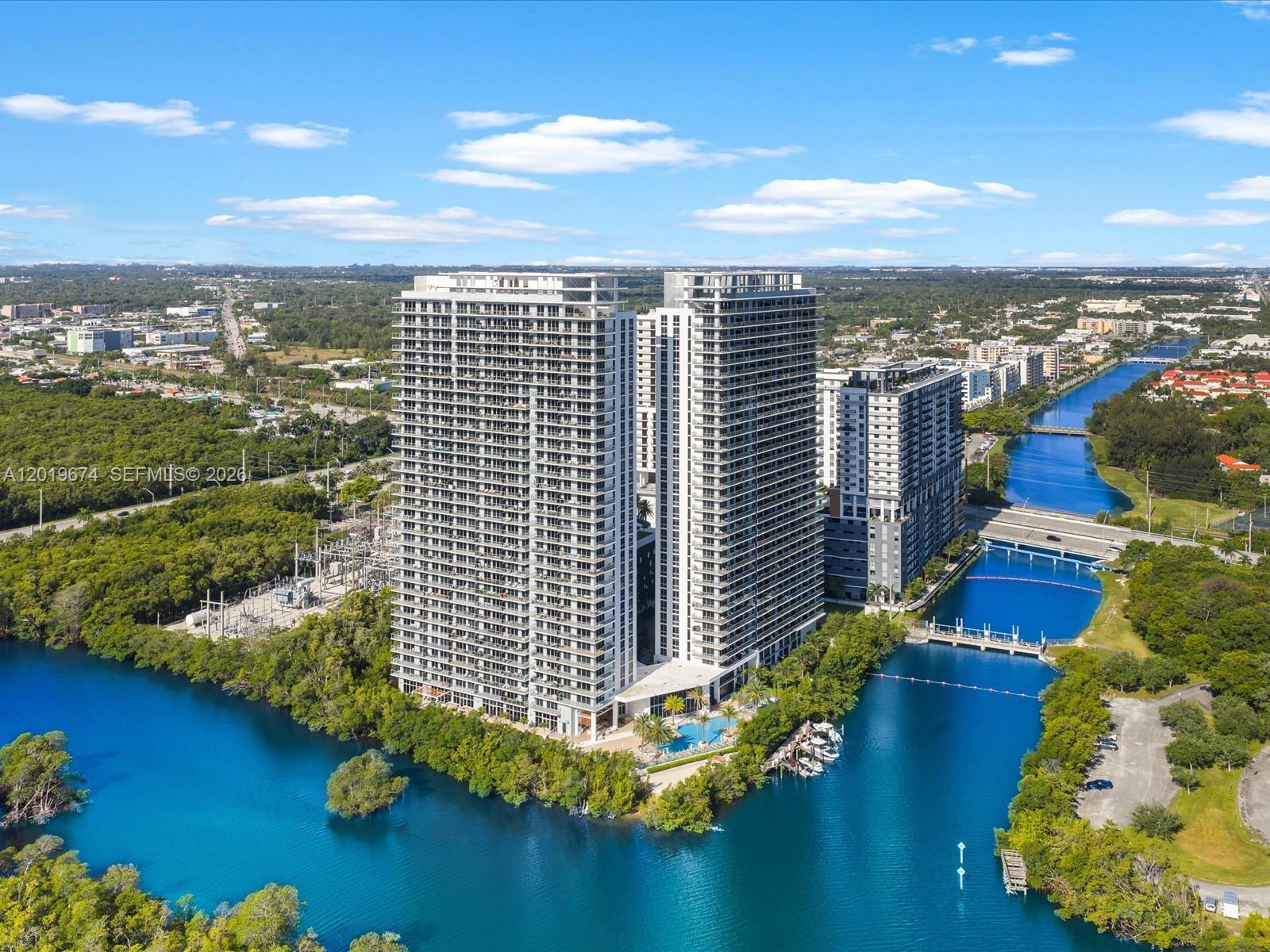 Experience luxury waterfront living at The Harbour, one of North Miami Beach’s premier resort-style communities, ideally located just minutes from Aventura, Sunny Isles Beach, and Bal Harbour. This beautifully maintained 2-bedroom, 2-bath residence offers the perfect combination of luxury, comfort, and convenience in the heart of South Florida. Featuring a spacious open-concept layout, the unit includes a large dining area that can easily be enclosed to create a den, office, or additional flex space. Thoughtfully upgraded throughout with modern lighting fixtures, electric blinds, and integrated network equipment, this residence is truly move-in ready. Floor-to-ceiling windows provide abundant natural light while showcasing breathtaking views of the canal front, city skyline, and ocean from nearly every room. Residents of The Harbour enjoy access to exceptional amenities, including a waterfront pool deck with cabanas, a poolside restaurant and café, a state-of-the-art fitness center, spa, kids’ play areas, sports courts, walking paths, a private marina and boat dock access, valet service, and 24-hour security. Conveniently located near beaches, shopping, dining, entertainment, and major highways. Info herein deemed reliable, subject to errors, omissions, or changes without notice—buyer to verify all information.