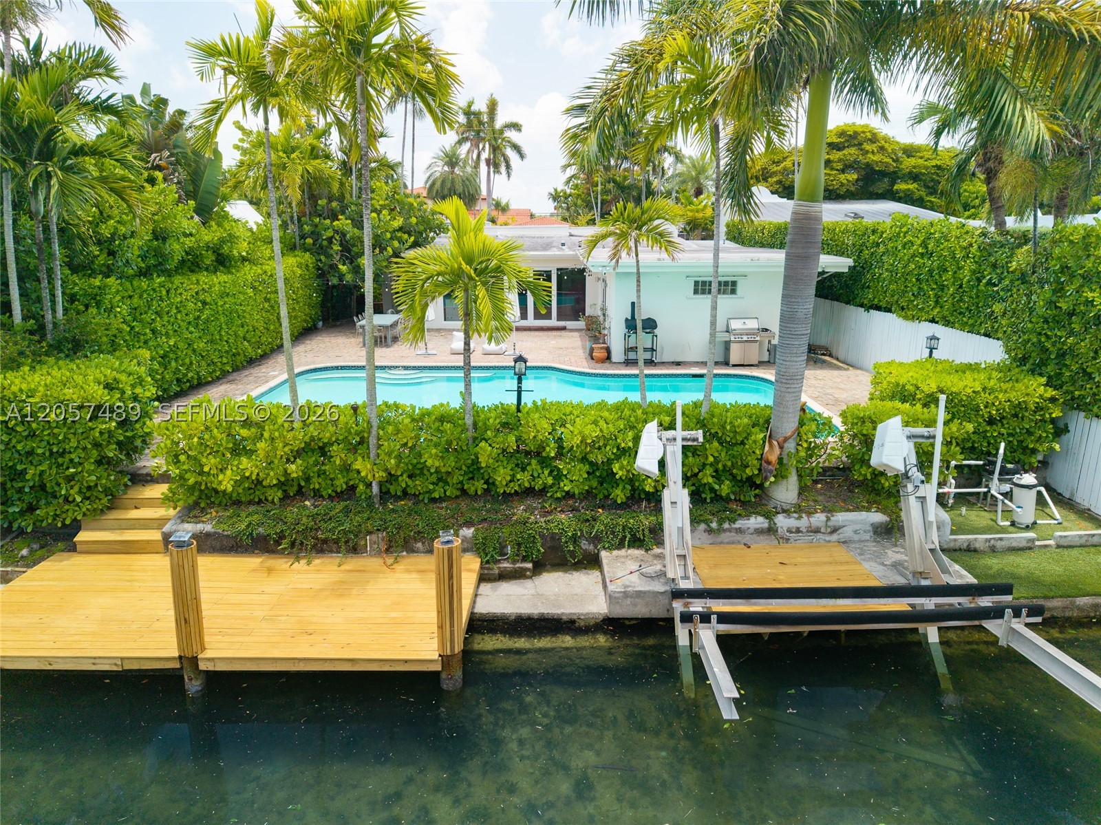 Beautifully renovated waterfront residence in the prestigious, guard-gated community of Biscayne Point. This move-in-ready home offers 4 bedrooms, 3 bathrooms, and over 3,200 SF of bright, open living space with soaring 10-foot ceilings, skylights, and expansive impact glass that fills the interiors with natural light. The chef’s kitchen is appointed with premium stainless steel appliances, abundant cabinetry, and a large island ideal for casual dining and entertaining. Multiple living and gathering spaces flow seamlessly to the private backyard, where an oversized pool, 60 feet of waterfront, private dock, and 7,000-pound electric boat lift create the ultimate boating lifestyle. Set on a 9,000 SF lot, this exceptional home is just minutes from the beach, top-rated schools, dining, golf, tennis, Bal Harbour Shops, and all that Miami Beach has to offer.