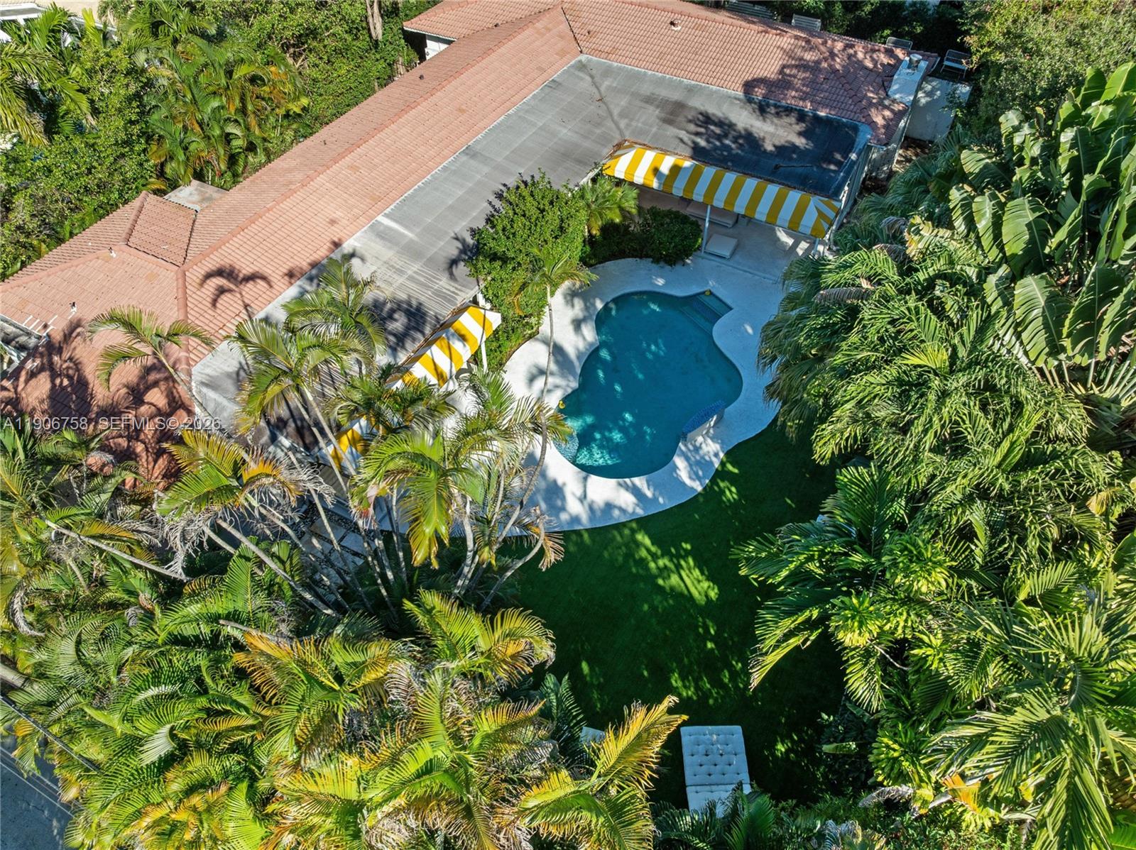 PRICED TO SELL!! A rare architectural gem in Miami Shores, where timeless Art Deco elegance meets modern European flair. Fully renovated yet rich in original character, this 4-bed, 4.5-bath residence sits on a 14,300 SF lot surrounded by lush privacy. Floor-to-ceiling impact windows flood the interiors with light, revealing terrazzo floors, stone accents, and a marble dining salon that blend Riviera sophistication with California ease. The heated saltwater pool, framed by iconic yellow awnings, creates a resort-style oasis made for entertaining. The expansive primary suite features dual walk-ins and a seamless indoor-outdoor flow. Steps from cafés, boutiques, and top schools, yet tucked in complete privacy... it’s a slice of the South of France, reimagined in Miami. No flood insurance required.