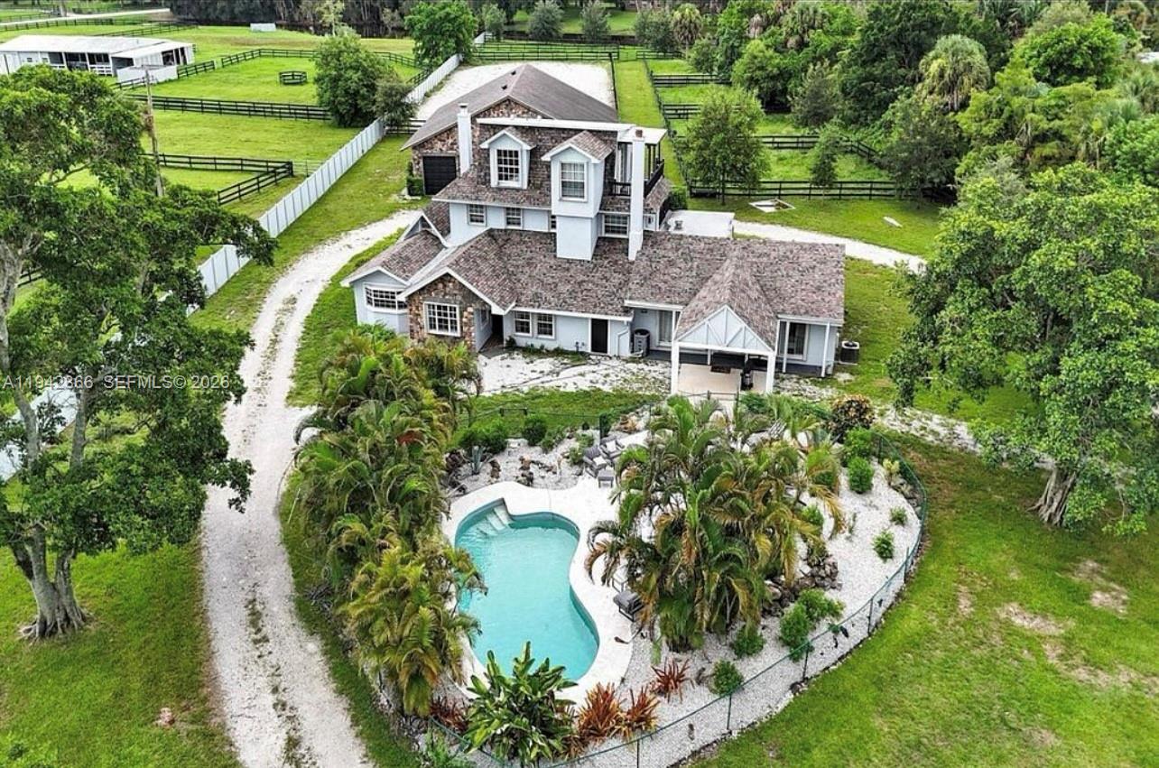 Expansive estate property situated on over two acres of land, offering privacy, space, and versatility. The residence features multiple living levels, wood flooring, and generous interior volumes throughout. Outdoor amenities include a resort-style pool and extensive parking capacity, including a detached garage suitable for multiple vehicles. The grounds allow for a wide range of uses and enjoyment, creating a rare opportunity for a large-lot residential setting.