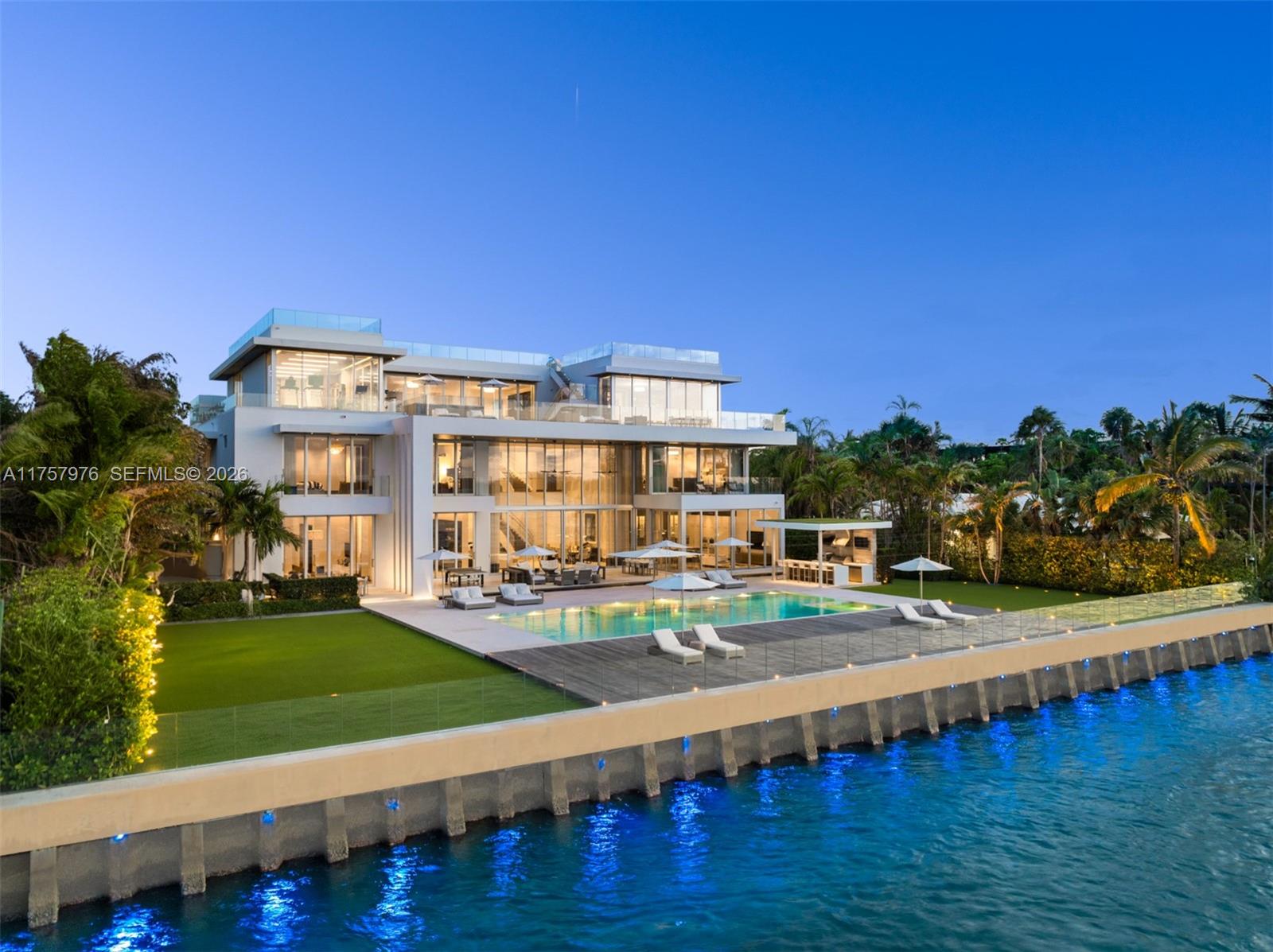 True trophy estate, this custom-built masterpiece spans 4 levels, 21,927SF of curated living spaces, redefining
luxury waterfront living in Bal Harbour. Nestled along 150’ of Biscayne Bay’s pristine coastline, the estate offers an
unparalleled experience on nearly an acre. Soaring ceilings, expansive open spaces & impeccable finishes, every
detail reflects modern elegance. Highlights include: rooftop oasis complete w/ a putting green, shuffleboard deck,
heated jacuzzi & sweeping bay views, along w/2 heated saltwater pools—one privately tucked into the expansive
terrace of the principal suite. State-of-the-art movie theatre, outdoor kitchen & Crestron smart home technology
round out the amenities, making this property not just a home but a statement of refined style & visionary design