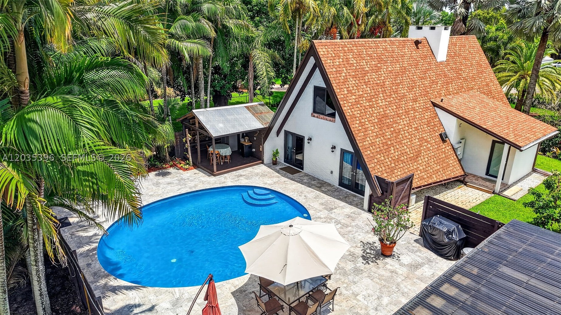 One of a kind A-Frame home w/ 2024 ROOFS, nestled on nearly an acre w/ convenient front & rear access in one of Davie's best neighborhoods. 3 bed, 2 bath pool home PLUS fully equipped charming 2 bed, 1 bath GUEST HOUSE in what feels like tree lined Coconut Grove. Main residence accessible off 24th St features updated open kitchen, WOOD BURNING FIREPLACE & two 1st floor bedrooms opening to pool area; spiral staircase leads to secluded primary suite above. Gorgeous marble pool area, updated covered deck space & full pool / cabana bathroom. Guest house, accessible via 23rd Ct, features complete kitchen, cozy living space, 2 bedrooms, bathroom & office/3rd bedroom - perfect for next gen, in-laws, guests/rental income, AirBNB, Investment Property. Two 2024 STORAGE SHEDS, workshops / craft spaces / home offices w/ air conditioning off pool area plus additional garage / storage & greenhouse / outdoor storage / workshop space. Lush mature palms & fruit trees & updated outdoor lighting & sprinkler system. Expansive space for all your pets, animals & hobbies, truly a rare find. Hurricane impact windows & doors. No HOA, horses / livestock permitted / equestrian area, room for boat trailers / RVs. Newly resurfaced, huge circular driveway off main house, plus two large driveways off guest house. Updated Well buried 200 ft deep, pumps, aerator & water softener. A true treasure offering privacy, space, versatility & A Rated Schools, minutes to Southwest Ranches, hospitals & highways.