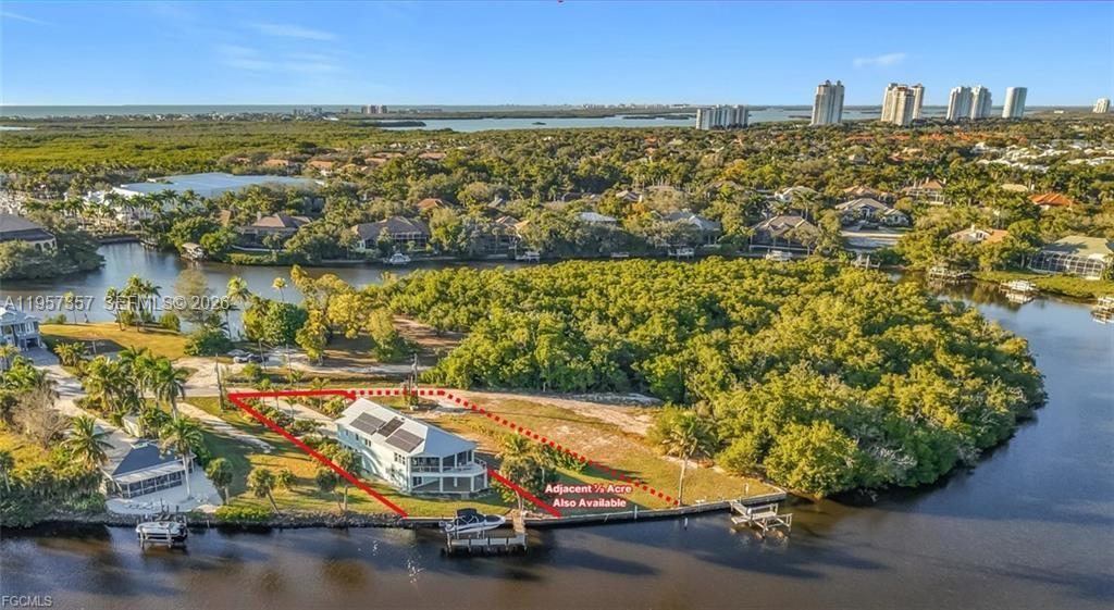 REFINED IMPERIAL RIVER LIVING WITH GULF ACCESS! Waterfront living at its finest on the Imperial River. This split-entry raised-ranch residence offers exceptional privacy, expansive water views, and direct boating access approximately one-half mile to the Gulf. Situated on approximately one-third acre, the property offers an estimated 75 feet of Imperial River frontage (+/-, subject to survey). The home features 2,005+/- square feet of living area and was built in 2015, incorporating hurricane-protection design. Construction highlights include a metal roof, hurricane-rated windows and doors, and a rip-rap seawall with a concrete cap. A low-maintenance composite dock with water and electric service is equipped with a 10,000-pound boat lift, offering durability and long-term waterfront enjoyment. The ground level features a formal entry, a full-service elevator, and a pass-through garage with front-to-rear doors leading directly to the dock. The elevator opens directly into the upper-level living area, where cathedral ceilings and abundant natural light frame sweeping river views. The kitchen is well appointed with top-of-the-line stainless steel appliances. The primary bedroom is generously sized with a private balcony, large walk-in closet with custom built-ins, and a beautiful ensuite bath featuring dual vanities and a spacious walk-in shower. The second bedroom also enjoys a private balcony and built-in closet storage. The third bedroom includes an ensuite bath.