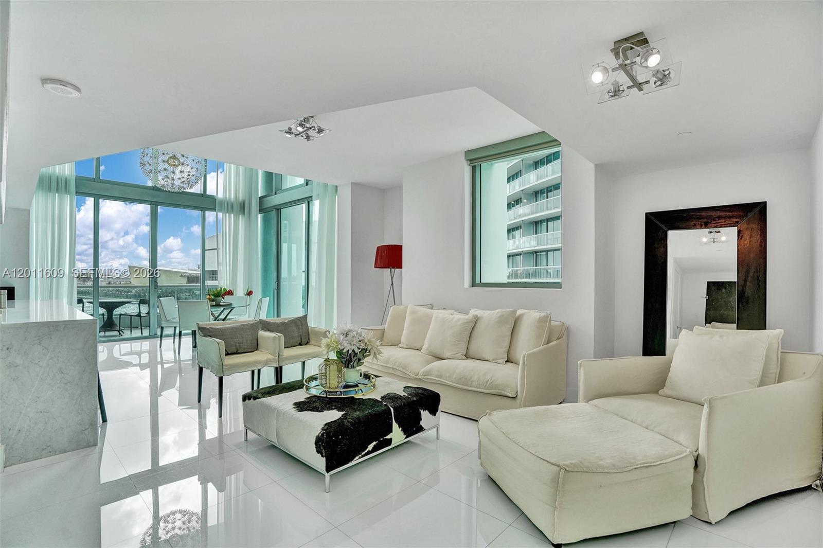 Commanding, unobstructed bay views set the tone for this fully furnished, bi-level corner townhouse, where dramatic 22-foot ceilings and expansive walls of glass create an impressive sense of volume and light throughout the main living area. The residence blends clean, modern design with high-end finishes, including sleek white glass porcelain flooring, top-of-the-line appliances, and custom-built closets that maximize both functionality and storage.

The open living and dining areas are designed for both everyday comfort and entertaining, seamlessly connected to the kitchen with premium appliances and refined cabinetry. The layout is exceptionally well planned, with one bedroom on the main level—ideal for guests or a home office—and two additional bedrooms upstairs, each with its own en-suite bathroom, ensuring privacy in every bedroom.

Both the primary suite and guest bedroom feature private balconies with direct water views, creating a true indoor-outdoor living experience. A rare offering combining scale, light, privacy, and refined finishes in a premier waterfront setting.