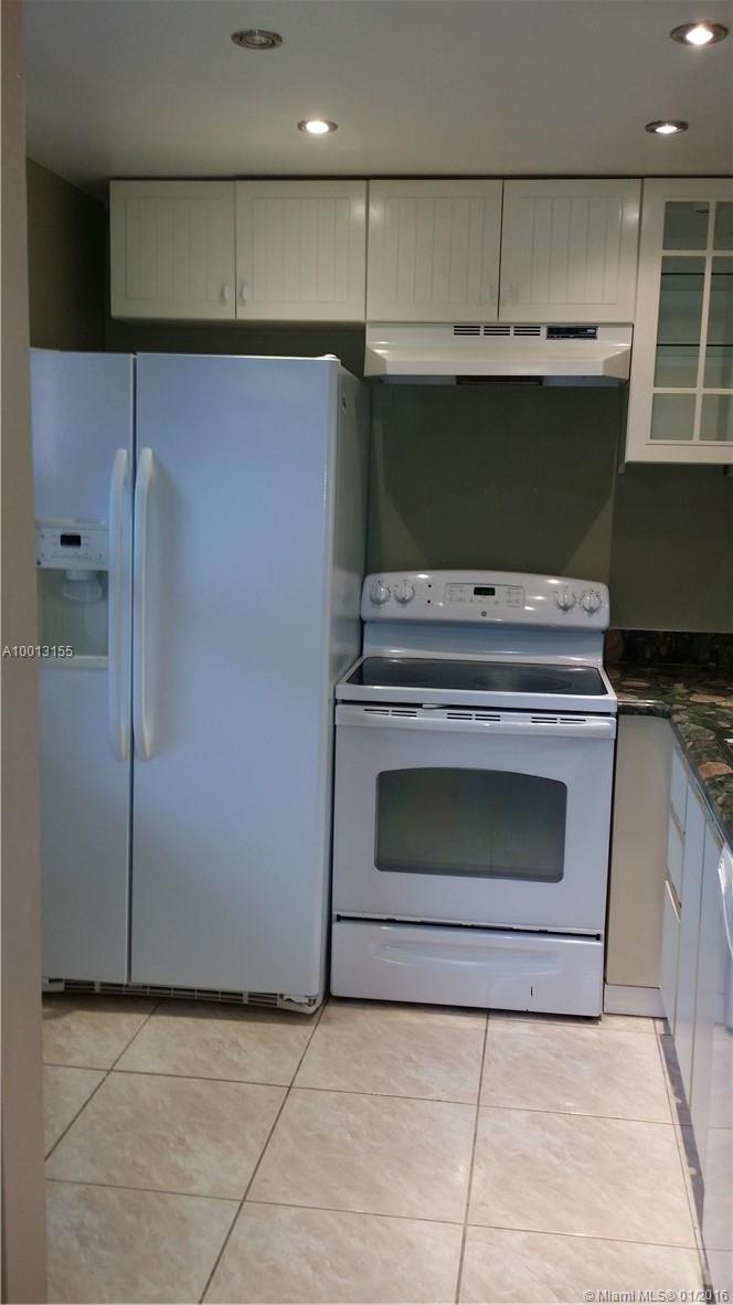 Immaculately clean corner unit on ground floor with peaceful golf and water views.  Back patio converted into additional room/Great for extra room or office space./ Real hard wood floor and beautiful tile throughout the unit and very nice granite kitchen counter tops. /  Enjoy the peaceful views and quiet lifestyle in this 55+ community.  The development amenities include: community pool, tennis courts, a  theater, exercise room and more.   A great central location in Sunrise with shopping and dinning.