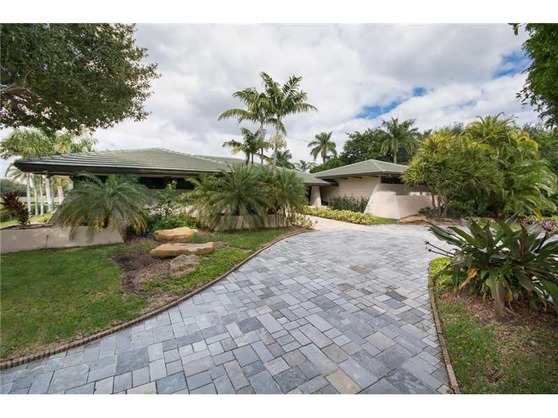 Located in one of Miami's premier waterfront communities this one-story residence boasts over 1.33 acres on a wide canal unencumbered by bridges. Over 9200 adj. sq. ft. of luxurious interiors w/ an exquisite paneled library, open formal areas, gorgeous wo od floors in the living room, volume ceilings, master suite w/sitting room, his & hers baths, walk-in closets & exercise room, island kitchen w/granite countertops & butler's pantry, swimming pool, lighted tennis court & 2-car garage. Re-do or build new.