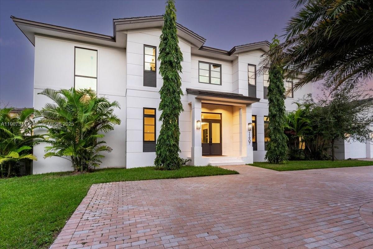 Breathtaking 2022 lakefront Modern Farmhouse with shimmering water views from nearly every room! This refined 2-story home offers 6 ensuite beds + den, 7 baths, and an ELEVATOR. High ceilings & expansive glass welcome you with tranquil views of the lake & lush grounds. The gourmet kitchen boasts Sub-Zero/Miele appliances, a large cooking island, & custom cabinetry, flowing into the elegant family room with a sleek wet bar. Two ensuite bedrooms are on the main level and the 2nd floor ftrs 3 addtl ensuites + den & a spectacular primary suite with a spa-inspired bath and boutique-style closets. Outside, a resort pool overlooks the water with a summer kitchen. Addt'l Ftrs: 2-car gar, generator, gated entry. Located near Top Rated Schools. It's not Miami, it's Pinecrest!