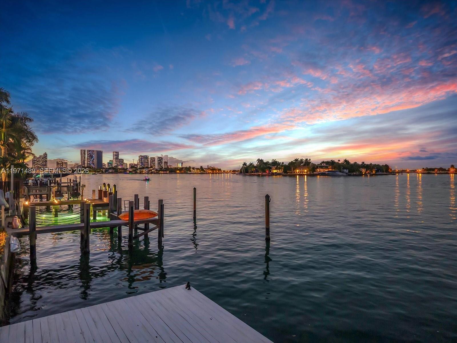 Exceptional waterfront residence on prestigious Hibiscus Island offering refined luxury and resort-style living. This stunning home features 6,005 sq ft of light-filled interiors with a 35-foot skylight atrium. Lush tropical landscaping, elegant fountains, and a resort-style outdoor area with pool, spa, and outdoor kitchen, creating the ultimate setting for entertaining. Enjoy direct bayfront living with a dock for up to a 60’ yacht. The primary suite offers serene water views. Hibiscus Island provides CMB police guard service plus tennis, pickleball, basketball courts, playground, and Fisher Island school bus service.