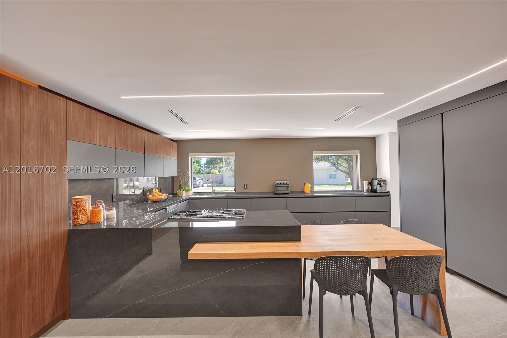 ARCHITECTURAL MASTERPIECE in the heart of Enchanted Lakes! Designed by a renowned Venezuelan architect, this brand-new residence seamlessly blends modern aesthetics with functional luxury. Every detail has been thoughtfully curated to deliver a sophisticated living experience in one of Miami’s most desirable neighborhoods. This stunning one-story home features 4 bedrooms and 4 bathrooms across a bright, open-concept layout with elegant porcelain floors, skylights, and designer finishes throughout. The spacious living and dining areas flow effortlessly into a sleek contemporary kitchen, perfect for entertaining and everyday living. The primary suite offers a spa-inspired bathroom with dual sinks and walk-in closets. Step outside to your private oasis featuring a resort-style pool, expansive deck, lush landscaping, and complete privacy. Additional highlights include hurricane shutters, circular driveway, utility/laundry room, exterior lighting, and gated entry. Located minutes from Aventura Mall, top-rated schools, dining, parks, and beaches. A rare opportunity to own a truly unique luxury residence in Enchanted Lakes.