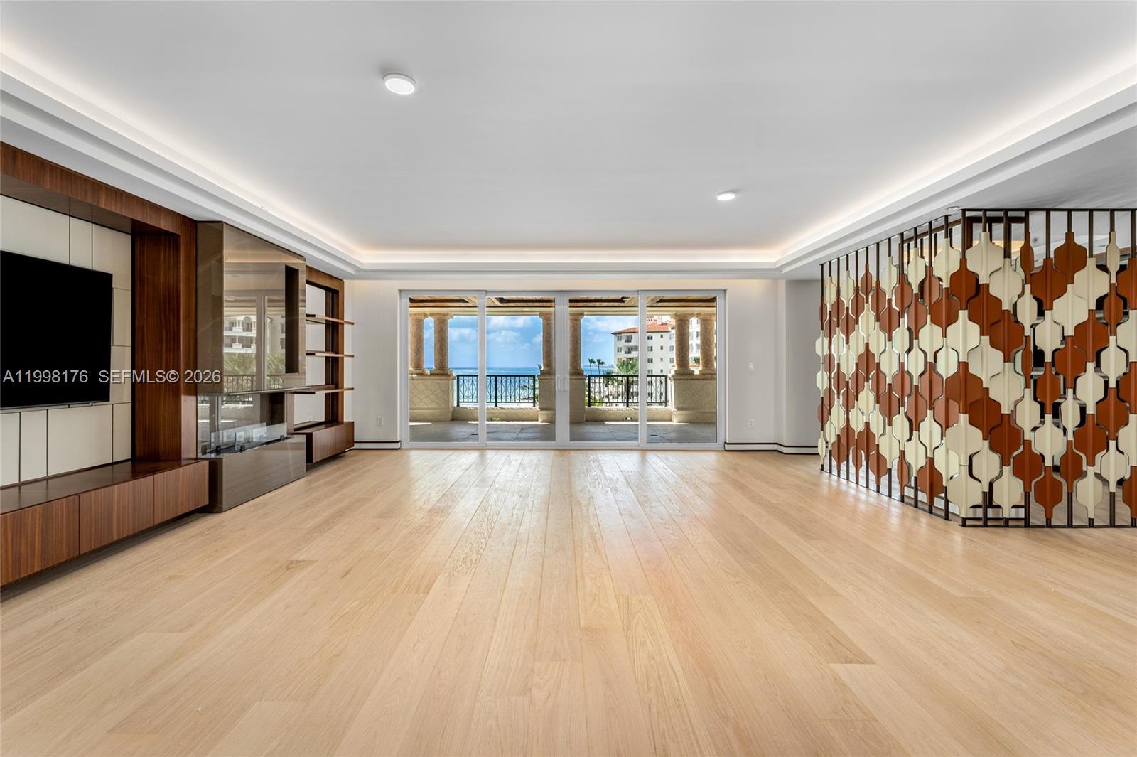 This spectacular brand new high-end oceanside renovation offers 3BR/3+1BA, and 3,567 SF of luxury. This chic contemporary unit features wide-plank oak floors & exceptional custom finishes throughout. A welcoming foyer with a custom American walnut entry door leads to a spacious open living room with designer millwork, eco-friendly fireplace, and cove lighting, seamlessly flowing to a wraparound oceanfront terrace with beautiful sunrise views over the beach and the Atlantic Ocean. An open dining area offers direct water views, a striking American walnut feature wall, and an adjacent bar, while a custom metal and leather divider creates a flexible office or den. The Italian-designed chef’s kitchen is a true showpiece, featuring soft-touch cabinetry with integrated lighting, a marble island with walnut inset, marble countertops/backsplash, Sub-Zero refrigeration & wine storage, and top-tier Miele appliances. A custom glass & American walnut wine cellar can accommodate approximately 300 bottles. The luxurious principal suite offers terrace access, Phillip Jeffries wall coverings, oak floors with leather inlays, custom wall panels, and a stunning glass walk-in closet with dressing area lighted shelves, plus a second concealed Italian-designed walk-in closet. Principal marble spa bath includes a book-matched accent wall, sunken tub, dual sinks, vanity, glass rain shower. Two additional bedrooms feature terrace access, Italian walk-in closets, and en-suite Carrara marble baths.