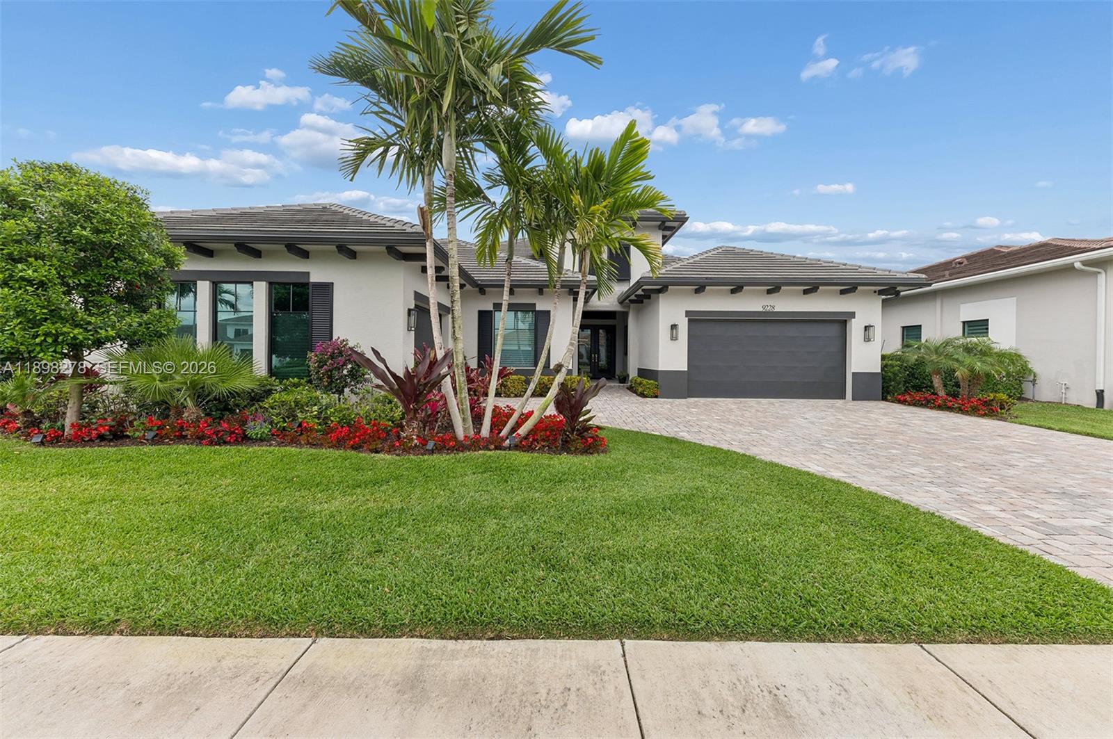 Perfectly priced and ideally situated in the sought-after Coral Isles enclave, this beautifully transformed residence is a move-in-ready designer showcase offering 3BR/3.5BA and 3,920 SF of refined luxury. Thoughtfully curated with high-end finishes and modern sophistication, the home delivers an effortless blend of comfort and style. A private backyard oasis sets the tone for relaxed outdoor living, featuring lush tropical landscaping, a sparkling pool, and a brand-new outdoor kitchen. Inside, a grand foyer with elegant marble inlay floors welcomes you into expansive living areas filled with natural light. The spacious great room is anchored by a dramatic custom feature wall with a sleek double-sided electric fireplace, creating a striking focal point that seamlessly connects the living and entertaining spaces. The gourmet kitchen is stunning, appointed with natural Quartzite countertops and backsplash, custom cabinetry, and premium appliances. A dedicated wine room enhances the home’s lifestyle appeal, complete with dual 155-bottle coolers and abundant storage space. Additional highlights include custom-built closets throughout, a beautifully finished marble powder room, central vacuum system, impact-resistant glass, and a whole-house generator for added comfort and peace of mind. This exceptional residence presents a rare turnkey opportunity in one of Palm Beach County’s most desirable newer communities, offering a seamless transition into luxury living.