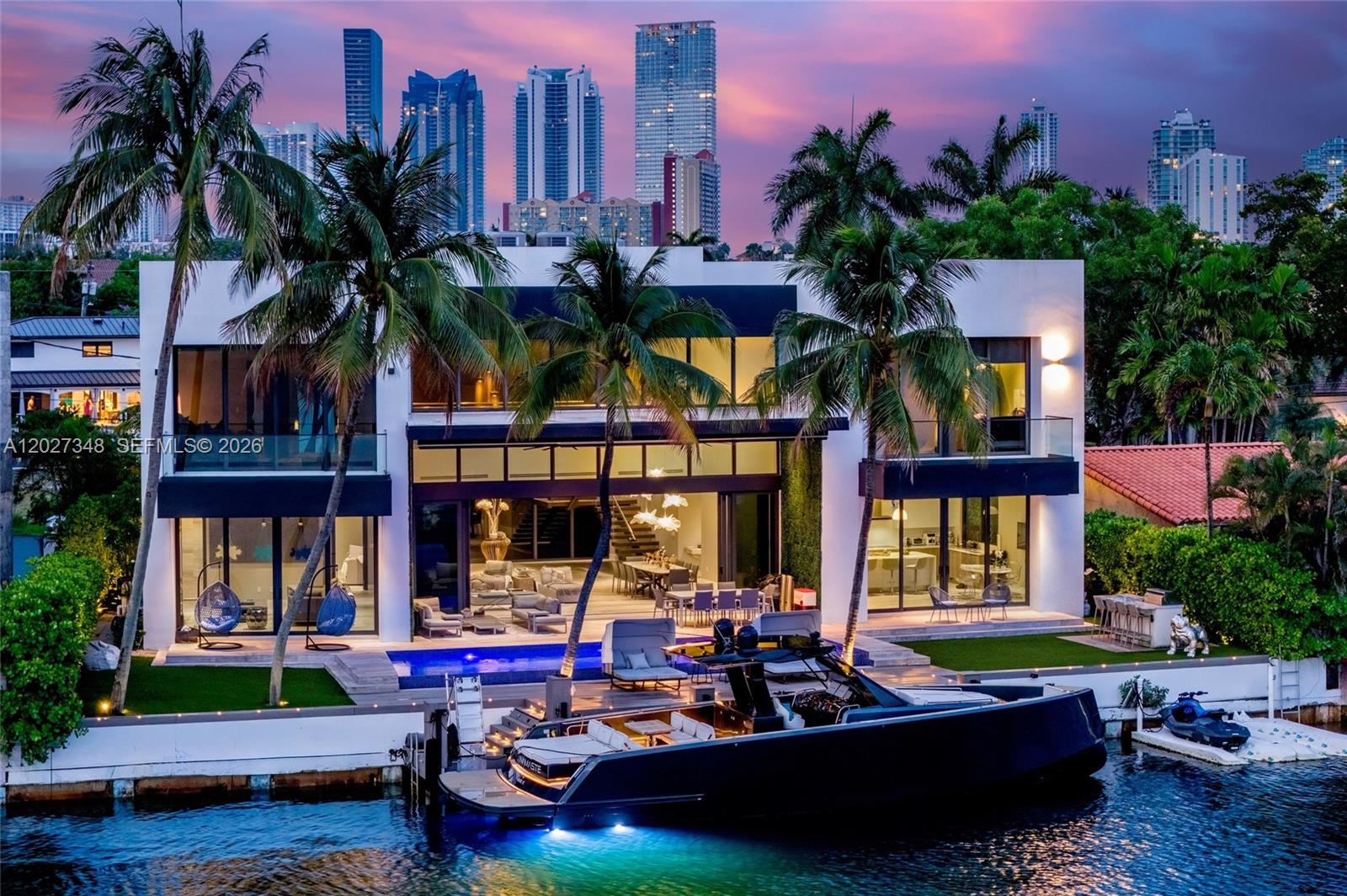 A spectacular modern waterfront estate commanding a premier position on 100 ft of prime water frontage along the open waters of Maule Lake, where dramatic architecture, panoramic bay views, and seamless ocean access define an elevated lifestyle within the exclusive gated enclave of Eastern Shores. Framed by walls of glass and striking contemporary design, the residence spans over 6,600 total SF across two levels with 5 en-suite bedrooms, 6 full and 2 half baths including a cabana bath, expansive entertaining spaces, a family room, staff quarters, private office/library, and gym. The lavish waterfront primary suite features dual spa-inspired baths, and custom Mia Cucina closets.

Refined interiors are complemented by limestone and engineered wood flooring, handmade Italian chandeliers, sleek custom finishes, and a fully integrated smart home system with Control4 automation, Sonos audio, motorized blinds and shades, security cameras, and four-zoned Carrier AC systems. A chef’s kitchen with Sub-Zero and Wolf appliances pairs with the summer kitchen for effortless entertaining.

The outdoor setting unfolds as a private resort-style retreat with a heated waterfront pool, expansive lounge terraces, built-in grill, and a double dock equipped with water and electricity for up to a 95-ft vessel, with unrestricted saltwater access to with no fixed bridges. Perfectly positioned moments from Sunny Isles Beach, Bal Harbour Shops, Aventura Mall, and premier dining destinations.