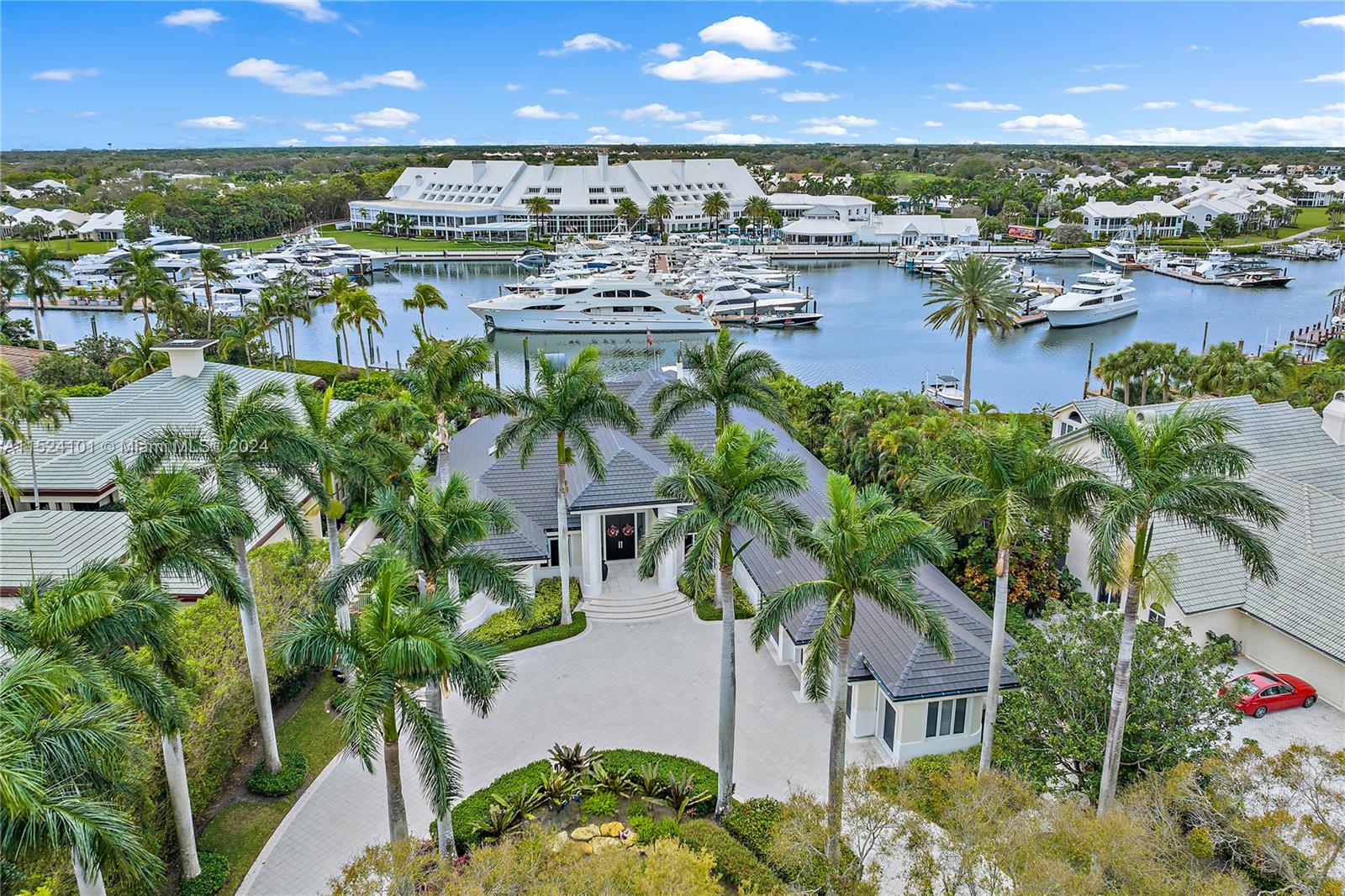 Spectacular Admirals Cove Estate Home on the Spyglass Lane cul-de-sac has a captivating view of the mega-yacht marina and nationally-acclaimed clubhouse, viewed through a 16-ft wall of glass! The interior dimensions are equally breathtaking. 17-ft ceilings create a majestic foyer and living room. The spacious gourmet kitchen has designer appliances, bkfst bar. His and Her WCs grace the sumptuous Primary suite, with an ensuite exercise room. Multiple accesses lead to the expansive coral stone patio and 40-foot saltwater pool and spa. Dock with 18000 lb lift and 2 PWC floats is within sight of the Intracoastal. A rare Tennis membership affords privileges in the ultra-deluxe Club, with 4 stylish dining venues, 45 professional-level golf holes, tennis, pickleball, idyllic spa and so much more!