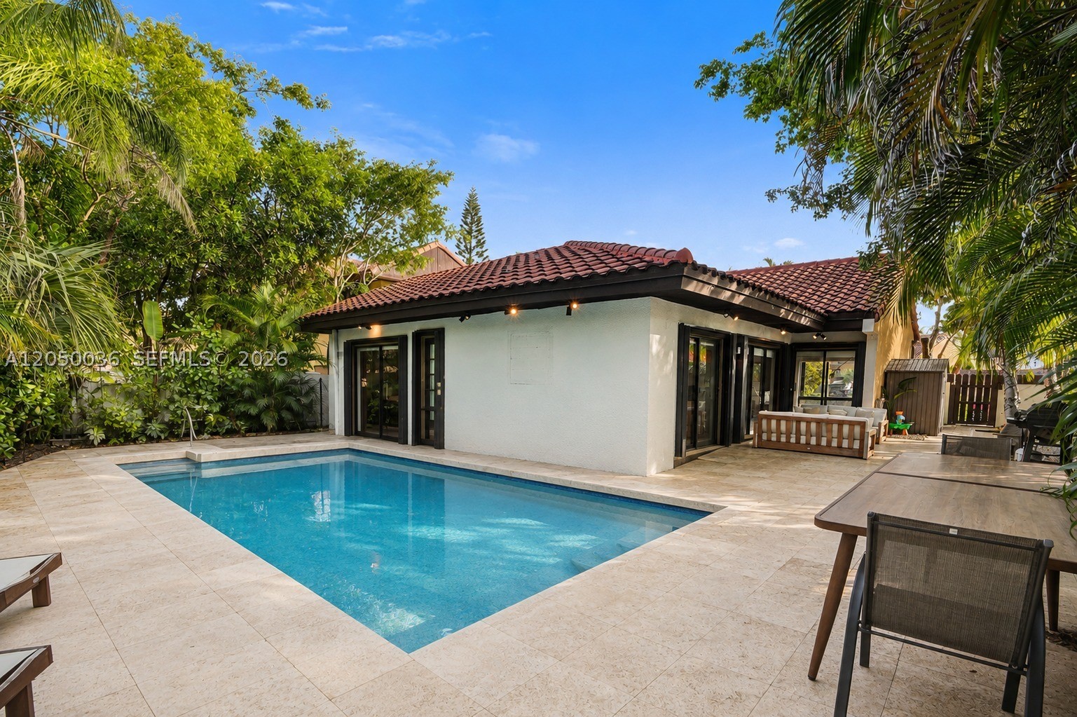 An exclusive gem inside the guard-gated community of Sky Lake Villas, a rare private-pool residence in a closed community where opportunities like this seldom come to market. Completely renovated in 2024, this 3-bedroom, 2-bathroom home has been renovated from the inside out. The heart of the home is a custom millwork kitchen, fully rebuilt with clean lines, integrated storage, and top-of-the-line finishes and appliances flowing seamlessly into the open living and dining areas. Both bathrooms were taken down to the studs and reimagined with floating vanities, oversized mirrors, and a bright, spa-inspired feel. Behind the finishes, the work is just as thorough: new plumbing and electrical (2024), a new roof (2023), a tankless water heater, and a brand-new A/C system (2025). The expensive items are already done. A split-bedroom floor plan delivers true privacy, with a custom walk-in closet in the primary suite and guest bedrooms opening directly to the pool through full-height sliding glass doors. A rare interior atrium fills the home with natural light and gives the layout a distinctive architectural moment. Outside, a new travertine terrace (2024) frames the pool and creates a resort-style retreat with fire pit, grill, and lush tropical landscaping for total privacy. Every element thoughtfully designed to fulfill your lifestyle. Turnkey, move-in ready, and minutes from Aventura, shopping, dining, and major highways. Schedule a showing today!