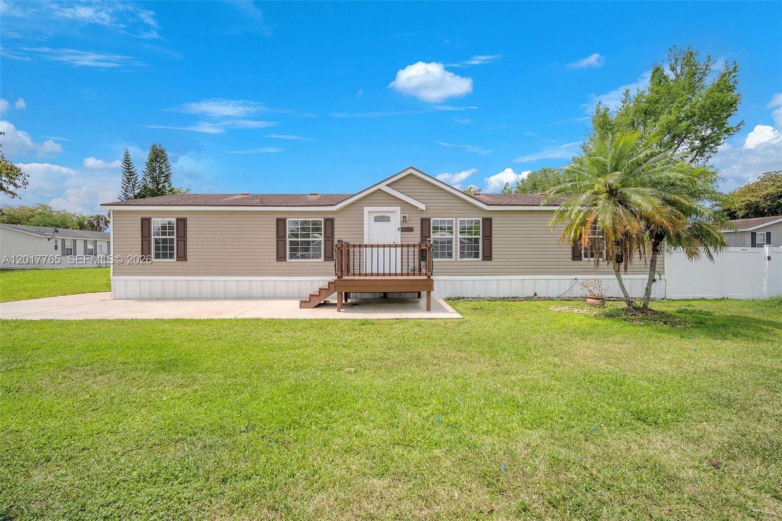 Turnkey, modernized 2008-BUILT 4BR/2BA double-wide home on an oversized CORNER LOT in the LAND-OWNED, all-ages community of Holly Lake, featuring a 2021 ROOF, 2022 WATER HEATER, canal-backed lot, and plenty of parking. Beautiful curb appeal, oversized driveway, and charming front deck with solar-lit posts welcome you in. Inside offers an open-concept layout with natural light, LVP flooring throughout, and a stunning updated kitchen with white quartz countertops, soft-close white shaker cabinets, LED high-hat lighting, deep sink with window view, stainless steel LG appliances, and walk-in pantry/laundry area with access to backyard patio. Split floor plan offers privacy, with ceiling fans and ample closet space in each bedroom. Both updated bathrooms feature walk-in showers and upgraded no-fog mirrors. Spacious primary suite includes a large walk-in closet and modern bathroom with double vanity. Enjoy a fully fenced white PVC backyard with expansive concrete patio, rear decks with steps, and a large storage shed with electric and lighting. Community amenities include 2 pools, clubhouse, tennis courts, gym, picnic areas, and more. Peaceful west Pembroke Pines location near open skies, nature, and sunset views. A-RATED SCHOOLS!! MUST SEE!! Schedule your private tour today!