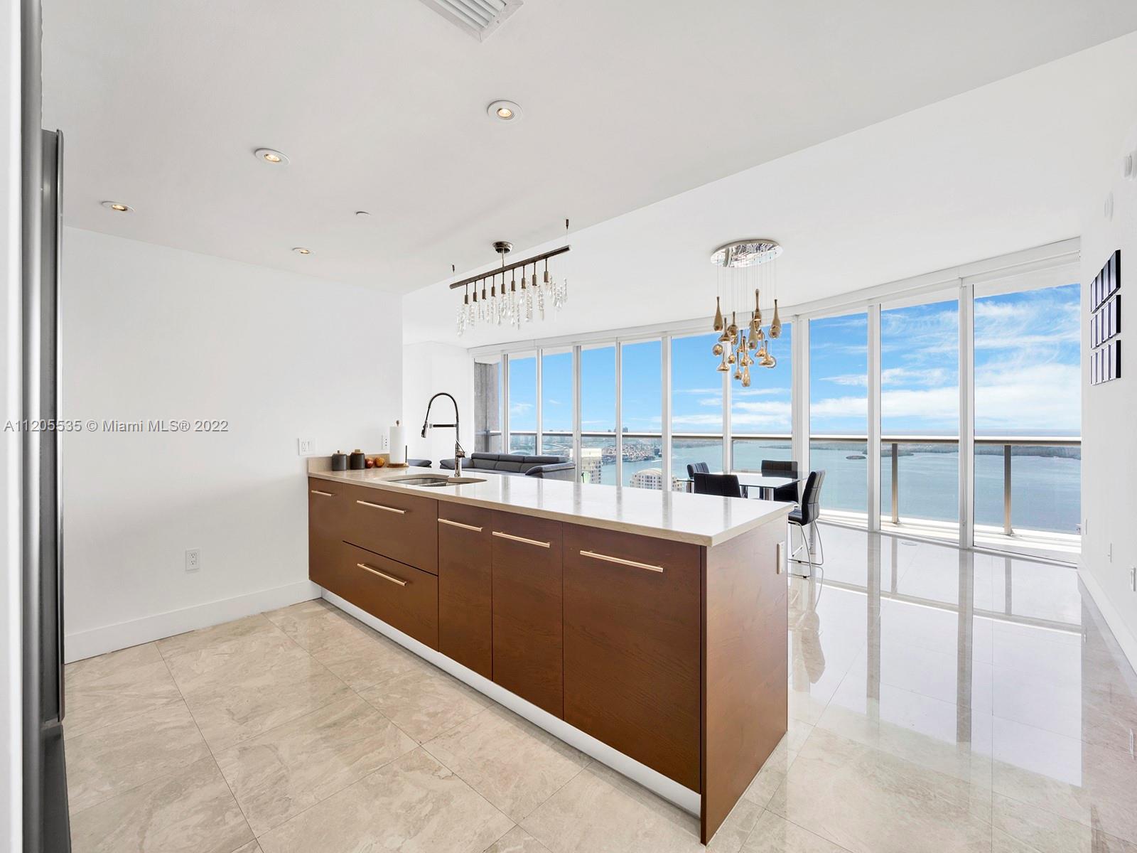 The best three bedroom layout in Brickell, with 180 degrees of heavenly views of bay, spanning from Sunny Isles to Key Biscayne. Immaculate unit with white porcelain tiles throughout, and built out closets. Oversized washer and dryer and gorgeous light fixtures. Perfect layout, with views from every room and window fixtures throughout. This unit owner will rent the second assigned parking space for $150. Some of the amenities include the largest swimming pool on the East coast, a theater, party room, large and fully equipped gym, with three rooms offering free exercise classes throughout the day, as well as, the most beautiful spa in Miami, with thermal pools.