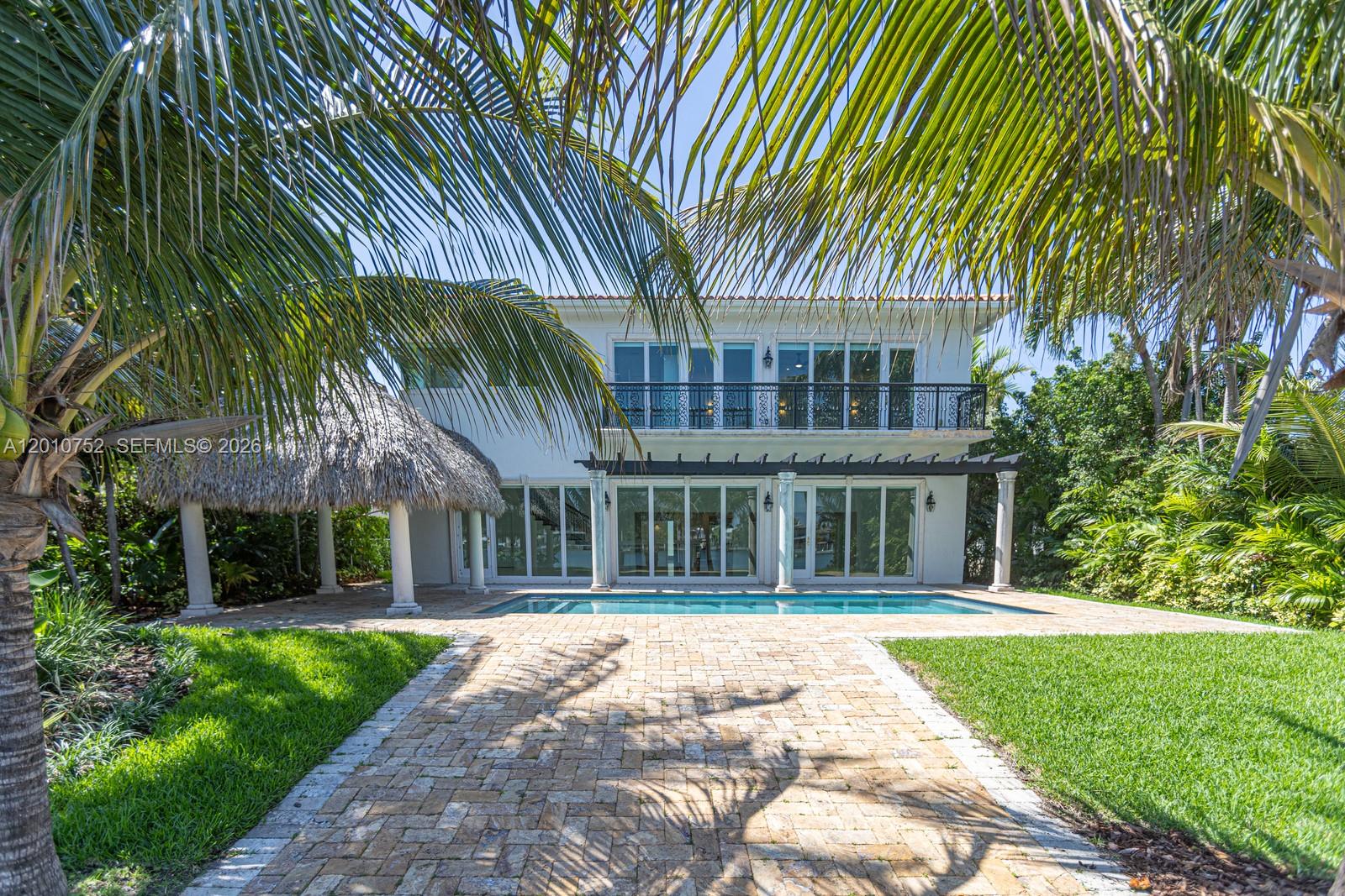 Mediterranean elegance meets Biscayne Bay living. This stunning 2-story waterfront home sits on the exclusive, guard-gated island of Normandy Shores in Miami Beach. Built in 2010 and fully renovated in 2025, this home offers 4,500 SF of refined living on an 11,000 SF lot with 65 FT of water frontage and open bay views.
Soaring ceilings, a chef’s kitchen, marble and Brazilian wood floors, and designer onyx bathrooms set the tone. The primary suite features a private veranda with panoramic water views. Outside, a resort-style pool, dock with boat lift, and two tiki huts complete the picture. Renovated top to bottom. New A/C, updated baths, custom closets, smart electrical, LED lighting, refinished floors, polished marble, motorized blinds, new pool equipment, salt system, irrigation, and fresh landscaping. Nothing was left untouched. Residents enjoy golf, tennis, basketball, clubhouse, and more. Turnkey waterfront living. Move in day one.