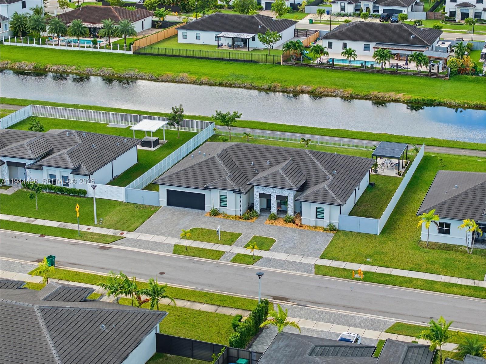 NO HOA in this WATERFRONT smart home built in 2022 on a quiet cul-de-sac with an 80-ft wide canal frontage for kayaking or small motor craft cruising with west-facing spectacular sunset views alongside a 2-way bike path. Huge 12,535-sq-ft lot offers room for a pool, RV, and boats. Five bedrooms/4.5 bathrooms, separate laundry room.  Electric water heater.  Better than new-builds with over $130,000 in upgrades, including espresso-frame impact windows and doors, custom closets and window treatments, custom tile flooring, gutters, privacy fencing, remote-controlled recessed lighting, pergola with adjustable louvers, and whole-house water filtration system. Unique to the other Galiano Point Hawthorne models is its great street design where you have a cul-de-sac on one end and waterfront dead-end on the other which reduces through-traffic and car speed.  Great for primary residence or for investors.    1.6 miles to Zoo Miami and close to schools, shopping, and Miami International Airport.  Bike straight from your backyard along the Black Point Marina canal to Larry and Penny Thompson Memorial Park—home to a freshwater beach and one of South Miami’s best-kept secrets: its classic waterslides, recently brought back to life opens this summer!