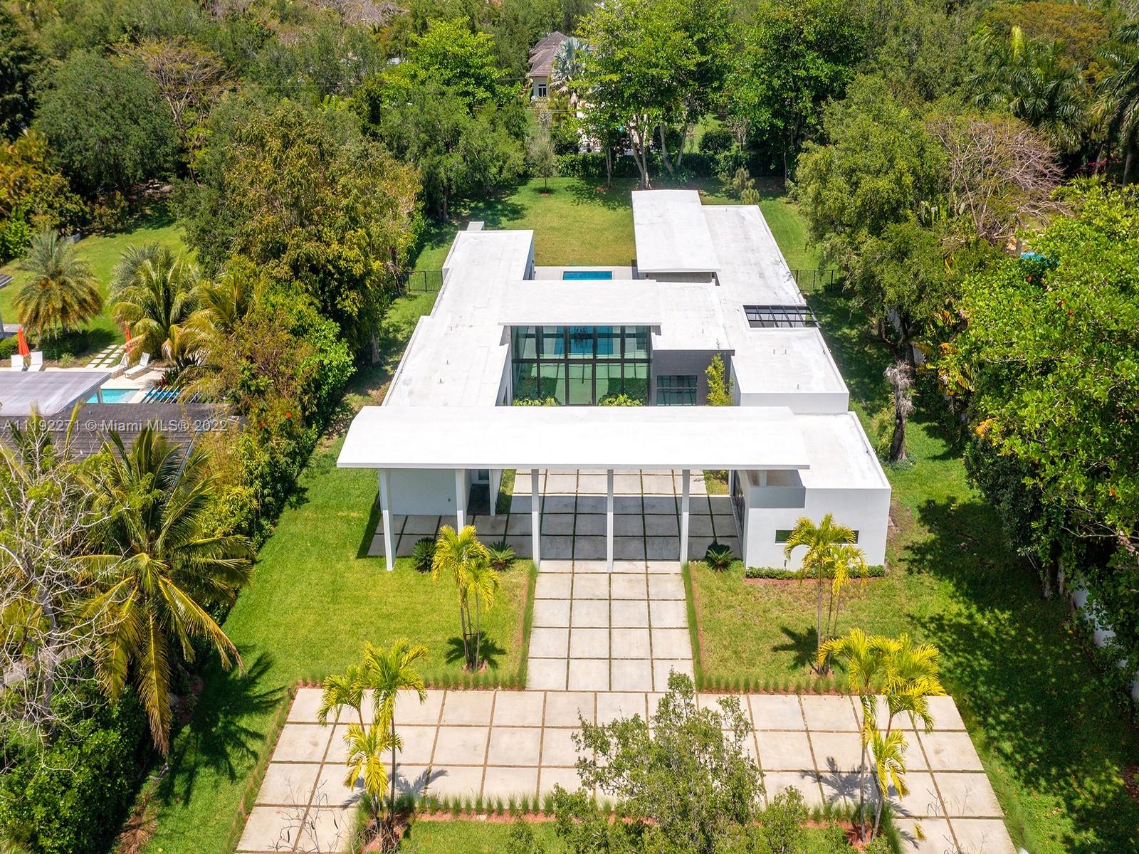 Cutting Edge brand-new modern estate in Pinecrest built w/the finest finishes and details. This stunning home welcomes you with floor to ceiling impact widows & doors and high ceilings. Discover a one-of-a-kind open floor plan offering panoramic views of the serene outdoors, formal living and dining, chef’s eat-in kitchen with Wolf & SubZero appl and spacious family room. This elegant smart home has it all w/state-of-the-art video, surround sound, and media rm/office. Lavish master suite offers walk-in closets, sitting area, spa bath w/ floating tub and rain shower. Find a spectacular backyard oasis featuring huge pool w/tanning ledge jacuzzi, covered terrace, built-in summer kitchen and huge yard. Additional features: porcelain flrs, maids rm, laundry rm, carport
& 2 car garage.