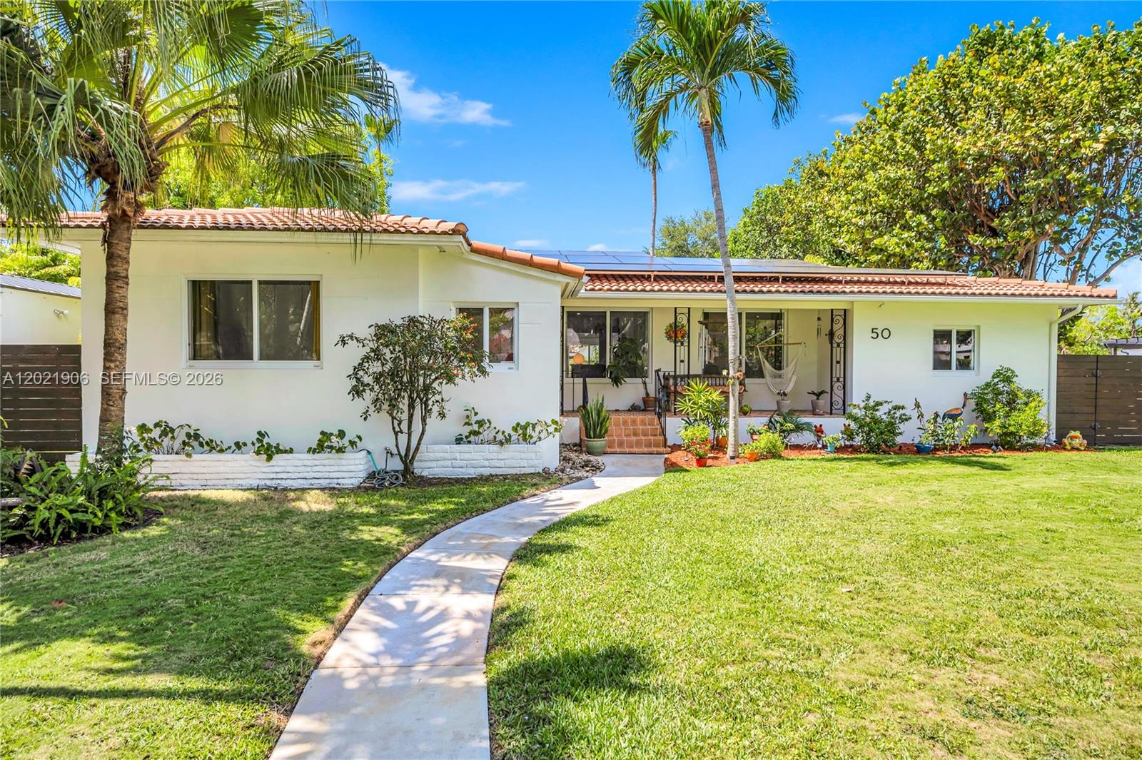 Tucked away on a quiet, tree-lined cul-de-sac, this Miami Shores midcentury charmer blends timeless design with seamless indoor-outdoor living. Beautiful original hardwood floors & midcentury ceiling trim preserve the home’s character, while thoughtful updates add comfort & functionality for modern living. The open-concept layout offers spacious living areas, with a renovated kitchen at the heart of the home. An expansive media/family room lined with windows overlooks the lush backyard oasis. The primary suite features multiple closets & double doors that open directly to the terrace & pool area. Renovated bathrooms, ample storage & complete impact windows & doors provide convenience & peace of mind throughout. Set on a large, private, leafy lot with room to expand, the backyard captures the essence of the Miami lifestyle. Enjoy a heated pool, generous patio spaces, & mature landscaping ideal for relaxing weekends & outdoor gatherings. A rare rear alley provides discreet driveway & garage access from the back of the property, enhancing both privacy & curb appeal. Solar panels with a battery backup system add energy efficiency. Non-flood zone location. Ideally situated just minutes from the shops, restaurants & cafés of Downtown Miami Shores, this home offers the perfect balance of tranquility, character & convenience in a prime location.
