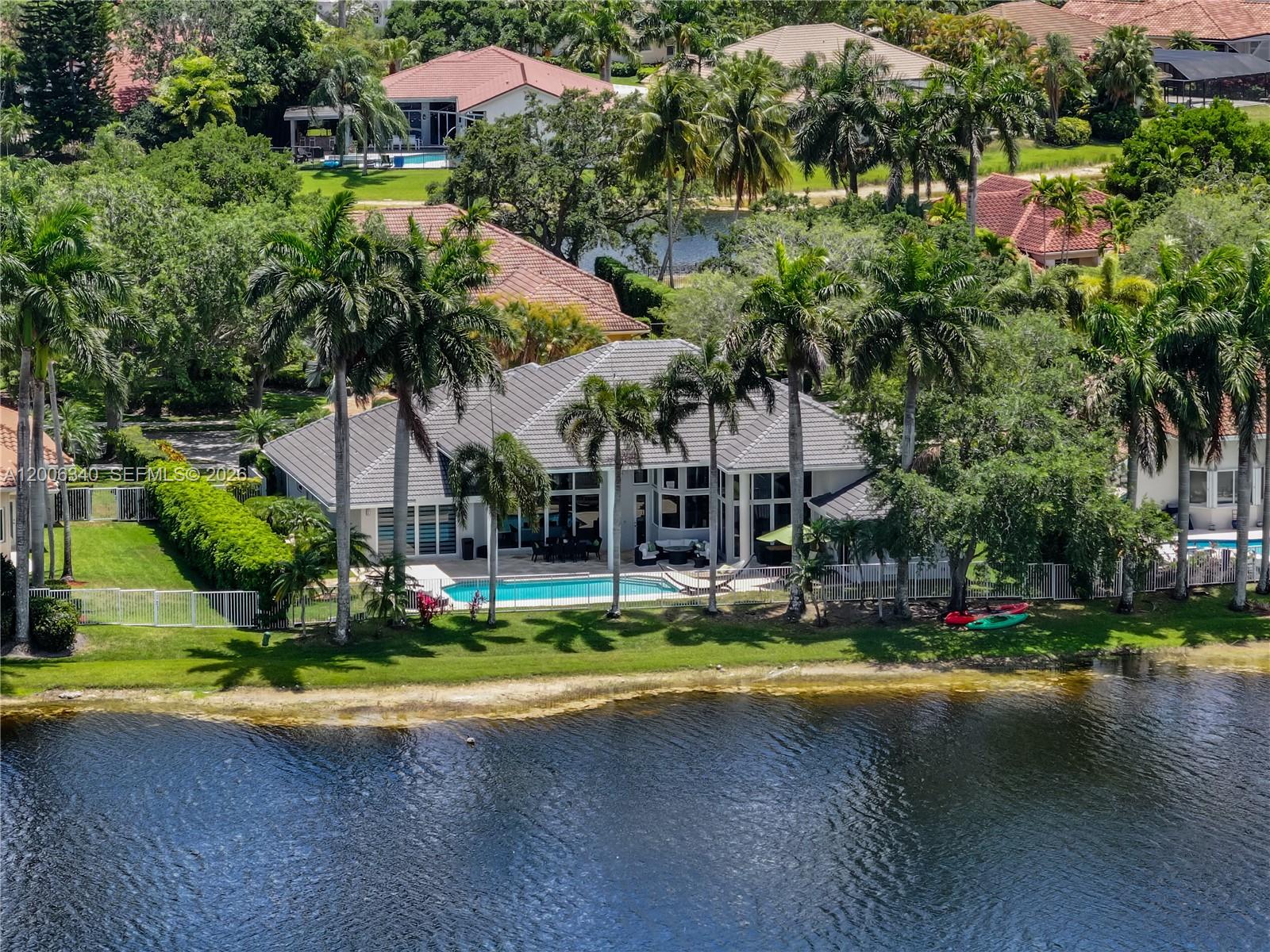 Stunning single-story estate in the exclusive Weston Hills Country Club, set on an oversized 0.41-acre waterfront lot with over 5,800 total square feet. This exceptional residence showcases soaring ceilings—higher than any other floor plan—and an elegant, open design throughout. Featuring 6 spacious bedrooms, 5.5 luxurious bathrooms, and a 3-car garage, the home has been beautifully updated with polished marble floors, fresh interior paint, a new roof, three new A/C units, and all-new impact windows and doors.  Designed for both grand entertaining and everyday living, the spectacular chef's kitchen boasts the latest in contemporary design and premium finishes, all overlooking the resort-style pool and breathtaking infinity lake views. Located within a prestigious golf course community and zoned for top-rated A+ schools, this remarkable estate offers the ultimate Weston lifestyle.