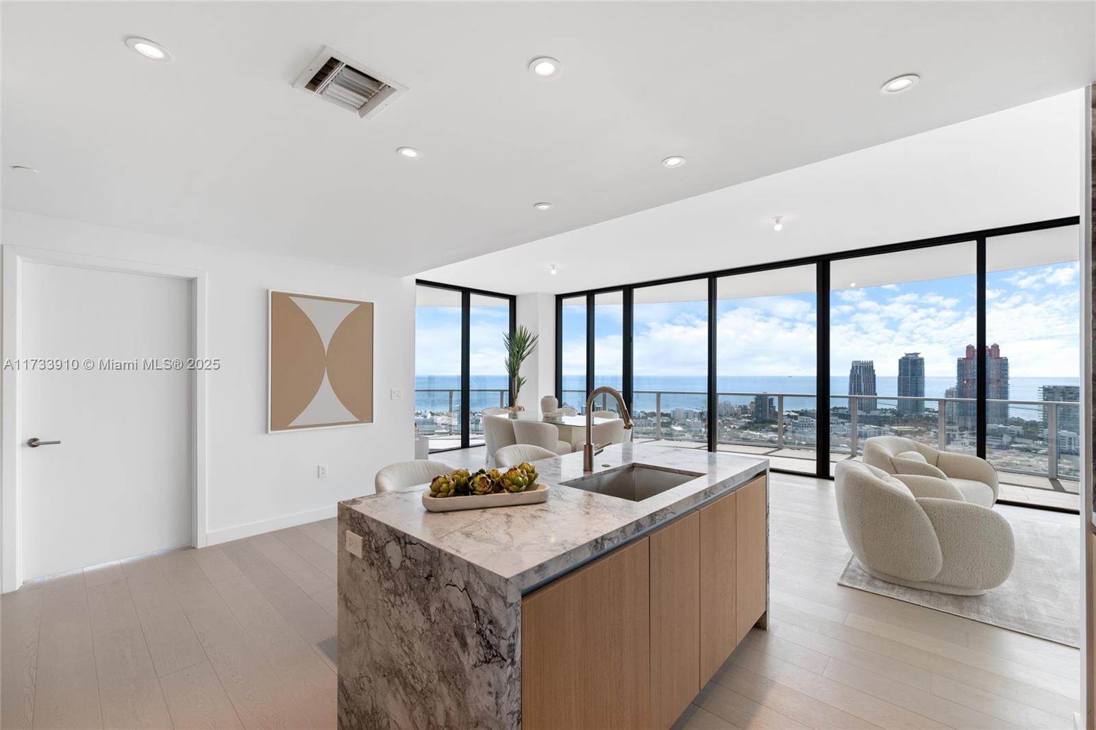 Welcome to Five Park, the epitome of luxury living in Miami Beach. Located in the prestigious South of Fifth neighborhood, this architectural gem by Arquitectonica offers 4,269 SqFt of expertly designed space. This brand- new corner unit features four bedrooms, four bathrooms, a powder room, and a private terrace, blending style and functionality seamlessly. With expansive windows, 10-foot ceilings, and a wraparound terrace, enjoy stunning ocean, bay, and city views. The Gabellini Sheppard-designed kitchen boasts Italian oak cabinetry, marble countertops, and Gaggenau appliances Residents access amenities including the exclusive Canopy Club on the 26th floor with private dining, wellness lounges, and personalized services.