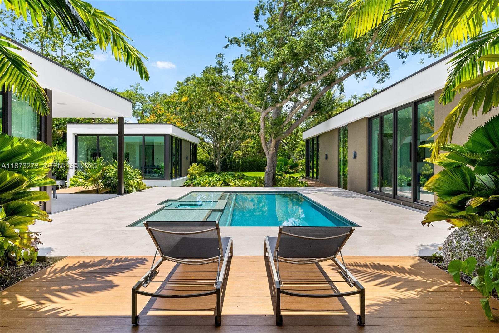 Set on a 39,639 sqft corner lot, this 2023 modern estate offers 5,745 sqft of luxury living. The main home features 6 beds, 6.5 baths, plus a detached 1 bed/1 bath suite. Designed for comfort and entertaining, enjoy a heated saltwater pool, hot tub, outdoor kitchen, putting green, and a two-car garage with EV charger. Premium finishes include Miacuccina millwork, 24x48 porcelain floors, soaring ceilings, a chef’s kitchen with Calacata Quartz, high-end appliances, & a large island. Smart features include a Control4 system, blackout shades, and more. Additional highlights: spa-style baths, walk-in pantry, laundry room, and fruit trees. Ideally located near top Pinecrest schools like Gulliver Prep, Palmetto, Beth Am, and more. Move-in ready in one of Pinecrest’s most desirable neighborhoods!