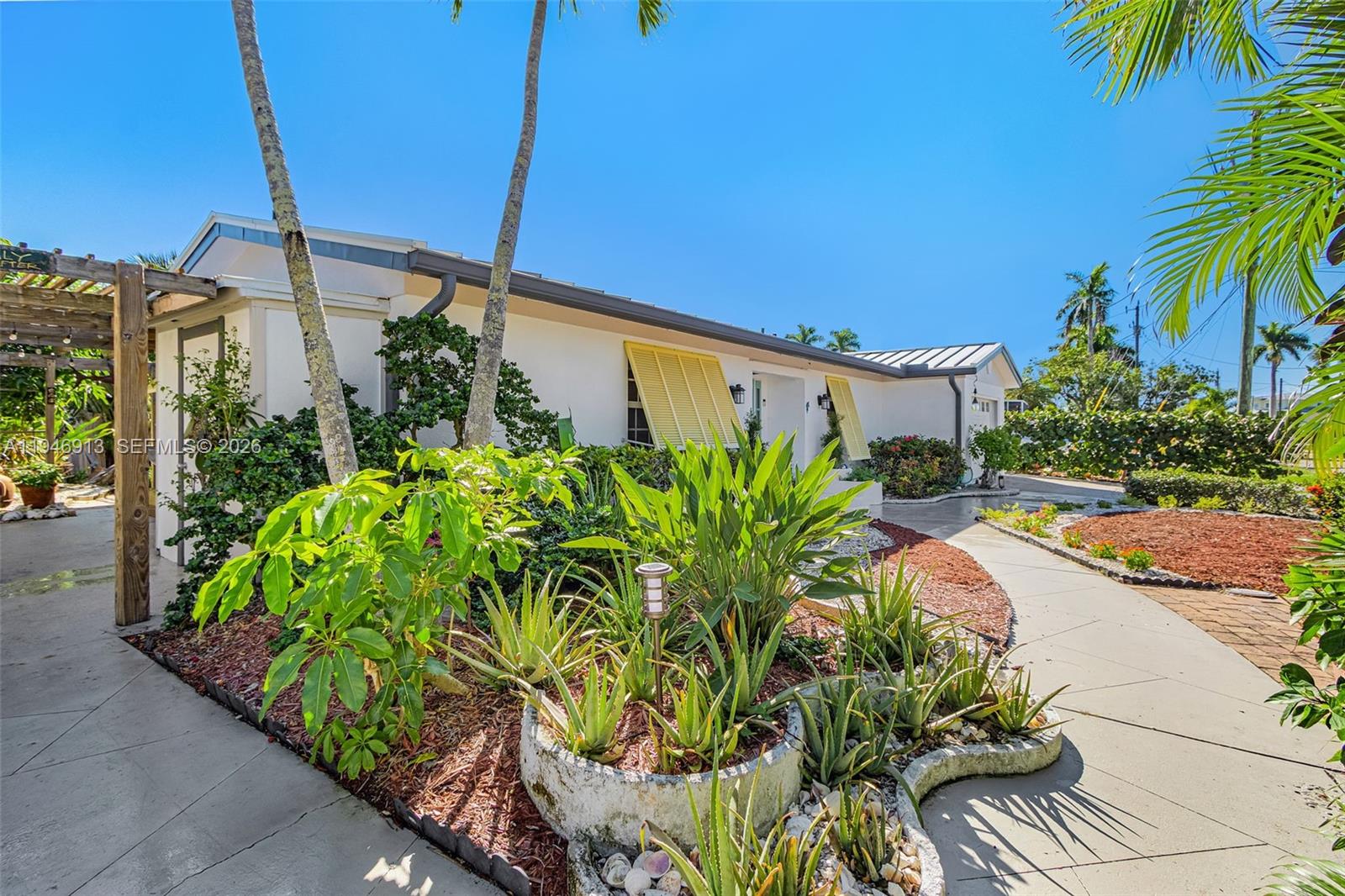 Welcome to your waterfront oasis - a modern, upscale, hurricane-resilient home designed for comfort, style and peace of mind. Offering 1,935 sq ft of meticulously maintained heated/cooled living space (2,692 sq ft total), this beautifully upgraded residence combines modern luxury with exceptional durability and low-maintenance living. Step inside to discover epoxy terrazzo flooring throughout and Enduraflood waterproof removable panelling, ensuring long-lasting protection and effortless upkeep. Top-rated standing seam metal roof. The home is equipped with multi-pane hurricane-rated windows, doors and shutters, giving you year-round confidence and safety. The modern chef's kitchen impresses with 75 sq ft of quartz countertops, new appliances, and rich hardwood cabinetry - perfect for cooking, entertaining, and everyday living. Enjoy a spacious 332 sq ft living room, complete with a custom wall unit, fireplace, and sleek floating TV hutch. Large rooms, contemporary bathrooms, and a stylish walk-in shower elevate the home's comfort and design. Outdoors, xeriscape landscaping provides beauty with minimal maintenance, and expansive 1,395 sq ft Trex concrete dock and deck lifestyle areas, creating an ideal setting for relaxing, hosting, and waterfront boating enjoyment. The deep-water access home features a reinforced seawall with cellular foam subsurface stabilization. This well-maintained home has a detailed improvement schedule available for interested buyers.