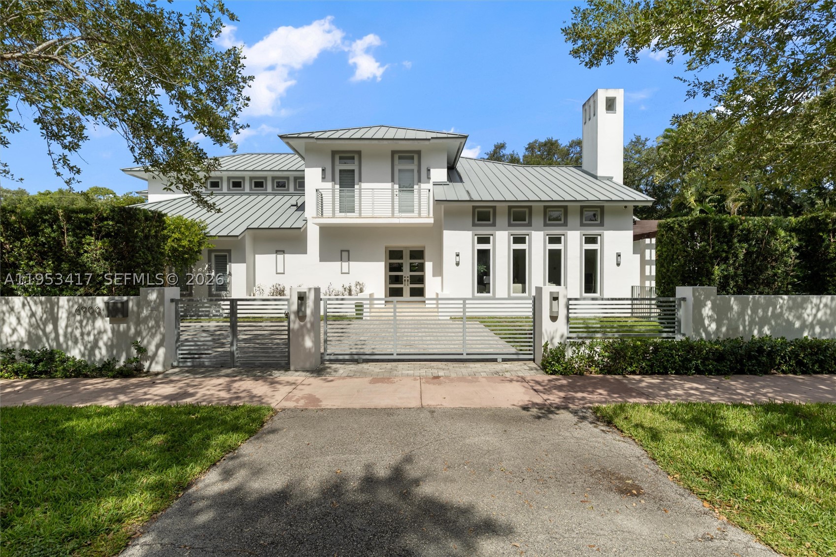 An exceptional executive home perfectly located in South Gables on a fully gated 15,000 sqft lot. Enter the ground floor through a light filled living area with double height ceilings and working fireplace. Large formal dining room leads an eat in kitchen with oversized island and top of the line appliances. Ground floor also features a huge family room and 2 bedrooms both with ensuite baths.  All rooms open to a sparkling tropical pool and large terrace, perfect for entertaining. The 2nd floor boasts an oversized primary suite with spa like bath and walk-in closet, a home office area and 2 bedrooms with ensuite baths and balconies overlooking the pool. This gated home has a 3-car garage with huge driveway and plenty of room for parking.
