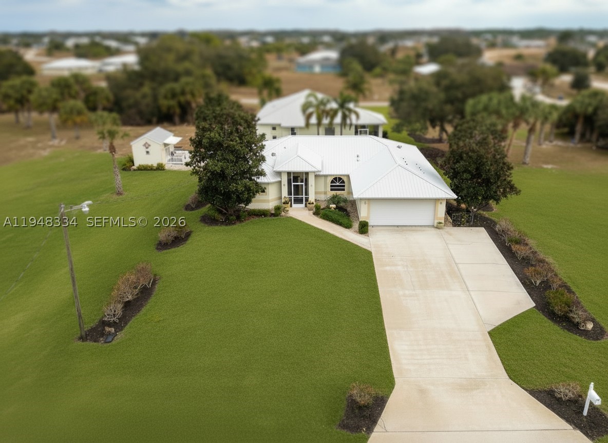 HOUSE + GUEST HOUSE + A STUDIO + A 5 CAR GARAGE, WITH 3 UNDER AIR on a .70+/- acre homesite with additional lot also available! Located in one of the nicest sections of Port LaBelle, near the Port LaBelle Marina, and features professional landscaping, irrigation system (on well, for irrigation only) the houses are on central water. The main house features hardwood flooring, screened entry and a huge, screened lanai, 2 Bedrooms + a den / office that can easily be transformed back into a 3rd bedroom. The guest house is handicapped and wheelchair accessible. It features an open floor plan with hardwood flooring, large bathroom with handicapped features, a kitchenette, huge, screened lanai, and a THREE-CAR AIR-CONDITIONED GARAGE / WORKSHOP with a driveway on Rogue Avenue. On the walkway between the homes is a studio with air conditioning, bathroom and kitchenette. This property is ideal for multigenerational living!