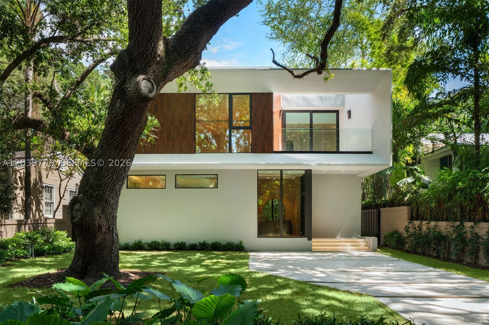 Rare new construction in the heart of South Grove, this exceptional contemporary residence by Varabyeu Partners Architects offers 4,651 SF of thoughtfully designed living space with 5 bedrooms, 5 full bathrooms, and 1 powder room. Surrounded by mature tropical landscaping and shaded by Coconut Grove's iconic tree canopy, the home seamlessly blends architecture and nature through expansive floor-to-ceiling impact glass, soaring ceilings, and an effortless indoor-outdoor design. Light-filled living and dining spaces flow into a designer kitchen featuring custom cabinetry, premium Thermador appliances, and an oversized island, while walls of glass overlook the resort-style pool and private gardens. The luxurious primary suite serves as a tranquil retreat with treetop views and a spa-inspired bath. Combining sophisticated modern design, exceptional craftsmanship, and a coveted South Grove location just minutes from top-rated schools, parks, marinas, dining, and shopping, this newly completed residence offers a rare opportunity to enjoy contemporary luxury in one of Miami's most sought-after neighborhoods.