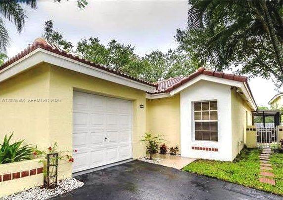 This beautiful corner residence is nestled in a quiet cul-de-sac within one of Weston’s most sought-after, meticulously maintained neighborhoods. Offering the perfect blend of comfort, style, and community, this home is zoned for Weston’s premier "A" rated schools, making it an ideal choice for families. The interior has been thoughtfully updated to meet modern tastes, featuring a sleek kitchen equipped with granite countertops and custom cabinetry that seamlessly flows into the bright living areas. Both bathrooms have been elegantly upgraded with contemporary finishes, and the master suite includes custom closet organizers to maximize storage and efficiency. Stepping outside, you will find your own private sanctuary. The property boasts a fully fenced backyard, providing ample space for pets or play, and a spacious screened-in, L-shaped porch—the perfect spot for morning coffee or evening relaxation. With a one-car garage and a wide driveway offering parking for two additional vehicles, this home provides both convenience and curb appeal. Experience the best of South Florida living in a peaceful setting that puts you minutes away from everything Weston has to offer. Property is tenant occupied.