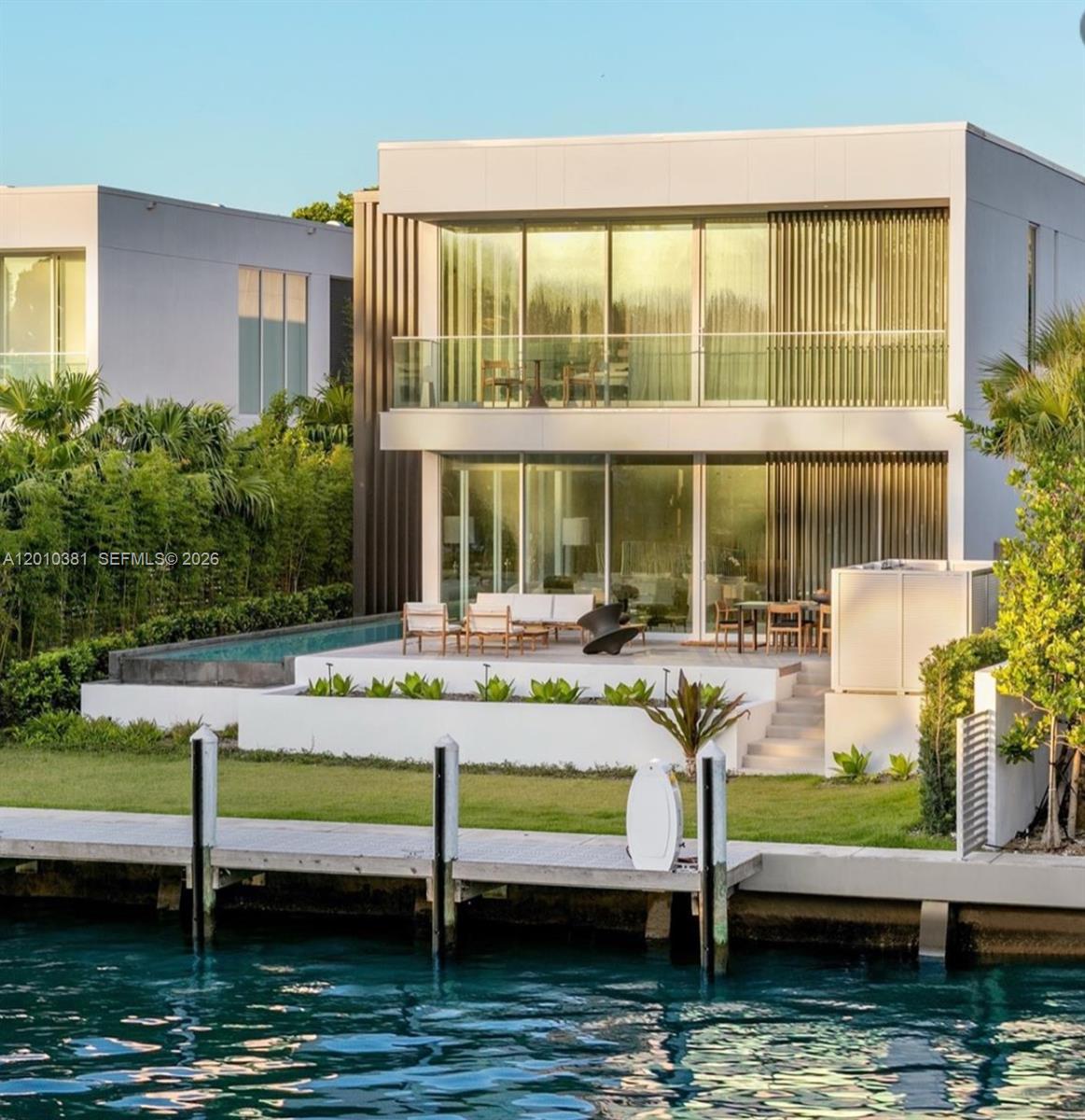 This one-of-a-kind, two-story waterfront villa, designed by Piero Lissoni & Ralph Choeff, combines modern tropical living with The Ritz-Carlton’s exceptional services. The contemporary design includes Georgette Limestone and wood floors, Boffi cabinetry, Gaggenau appliances with a gas range, Ipe hardwood decking, Fantini faucets, and a whole-house gas generator. Situated on Surprise Lake with private dock access to Biscayne Bay, the Intracoastal Waterway, and the Atlantic Ocean, it offers privacy while enjoying world-class amenities and services. Owners also have access to the main condominium building’s amenities and restaurant.