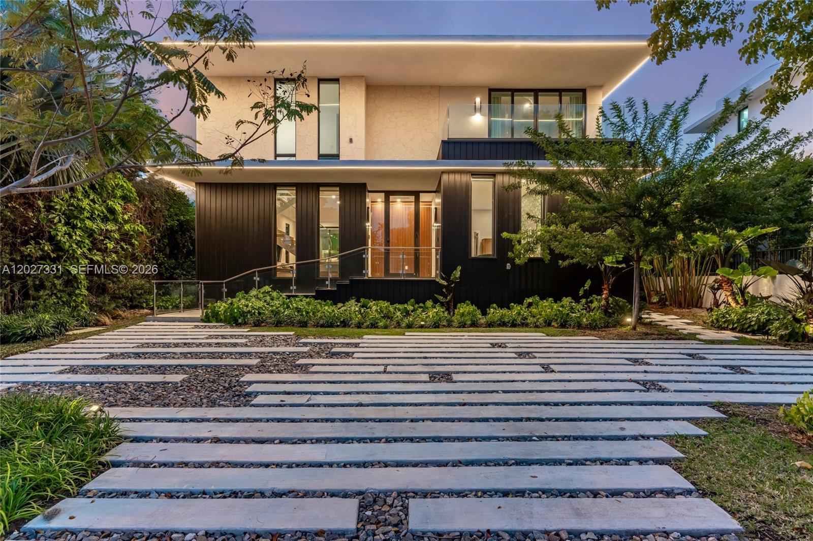 Modern luxury meets tropical elegance in this 4-bedroom, 4-bath contemporary residence in one of Miami Beach’s most desirable neighborhoods. Offered unfurnished, this two-story home features clean architectural lines, warm natural finishes, and light-filled open living spaces that create the perfect canvas to make it your own. Decorated by a Brazilian interior designer, the home is enhanced with beautiful wallpaper and curated details that elevate each space with texture and character. The main level offers a spacious living and dining area with a custom wood accent wall, sleek floating staircase, and floor-to-ceiling impact glass doors that seamlessly blend indoor and outdoor living. The chef’s kitchen features contemporary cabinetry, quartz countertops, premium stainless steel appliances, and a large center island, opening to a covered terrace ideal for entertaining. Upstairs, the primary suite includes a private balcony, walk-in closet, and spa-style bath with dual vanities, soaking tub, and oversized rain shower, while additional bedrooms offer modern finishes and ample storage. The private backyard showcases a covered summer kitchen, outdoor dining area, and lush tropical landscaping with green space for relaxing or gatherings. High ceilings, recessed lighting, and impact windows and doors complete this exceptional home, ideally located just minutes from beaches, top schools, dining, and shopping, offering privacy, convenience, and the ultimate South Florida lifestyle.