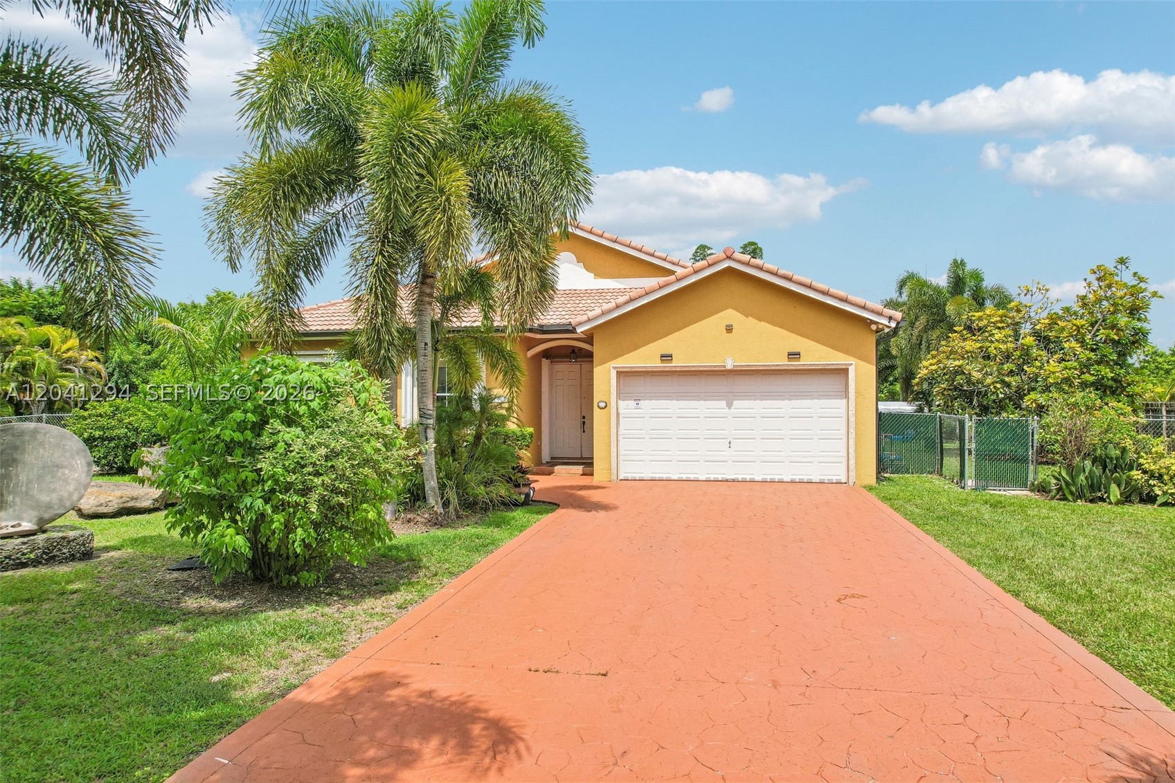 Tucked away on nearly an acre in the heart of The Redlands, this 4 bed 2 bath pool home is the kind of private estate people drive past every day and never get to see behind the gates. Built in 2002 with a classic barrel tile roof, full Estates zoned lot, no HOA, well and septic so no water bill. True split floor plan keeps the primary suite privately away from the secondary bedrooms. Bright open living and entertaining space, dedicated office, walk in closets, dual vanity baths, built in sound system, pantry, crown molding throughout. The home flows from the front gallery straight out to the covered patio. Outside is where it tells its story. A large in ground pool anchors the backyard, framed by a columned covered terrace built for long weekends and big gatherings. Beyond the pool sits something almost no home in Miami can offer, a private tropical fruit grove with 67 cataloged varieties. Over 40 mango selections alone, plus avocados, bananas, lychee, longan, mamey, soursop, jackfruit and dragon fruit, all curated tree by tree. Fully fenced and private, cameras, floodlights and doorbell camera in place, and room to roam in every direction. This is Redlands living the way people picture it, space, privacy, fruit on the trees, and a pool waiting at the end of the day.