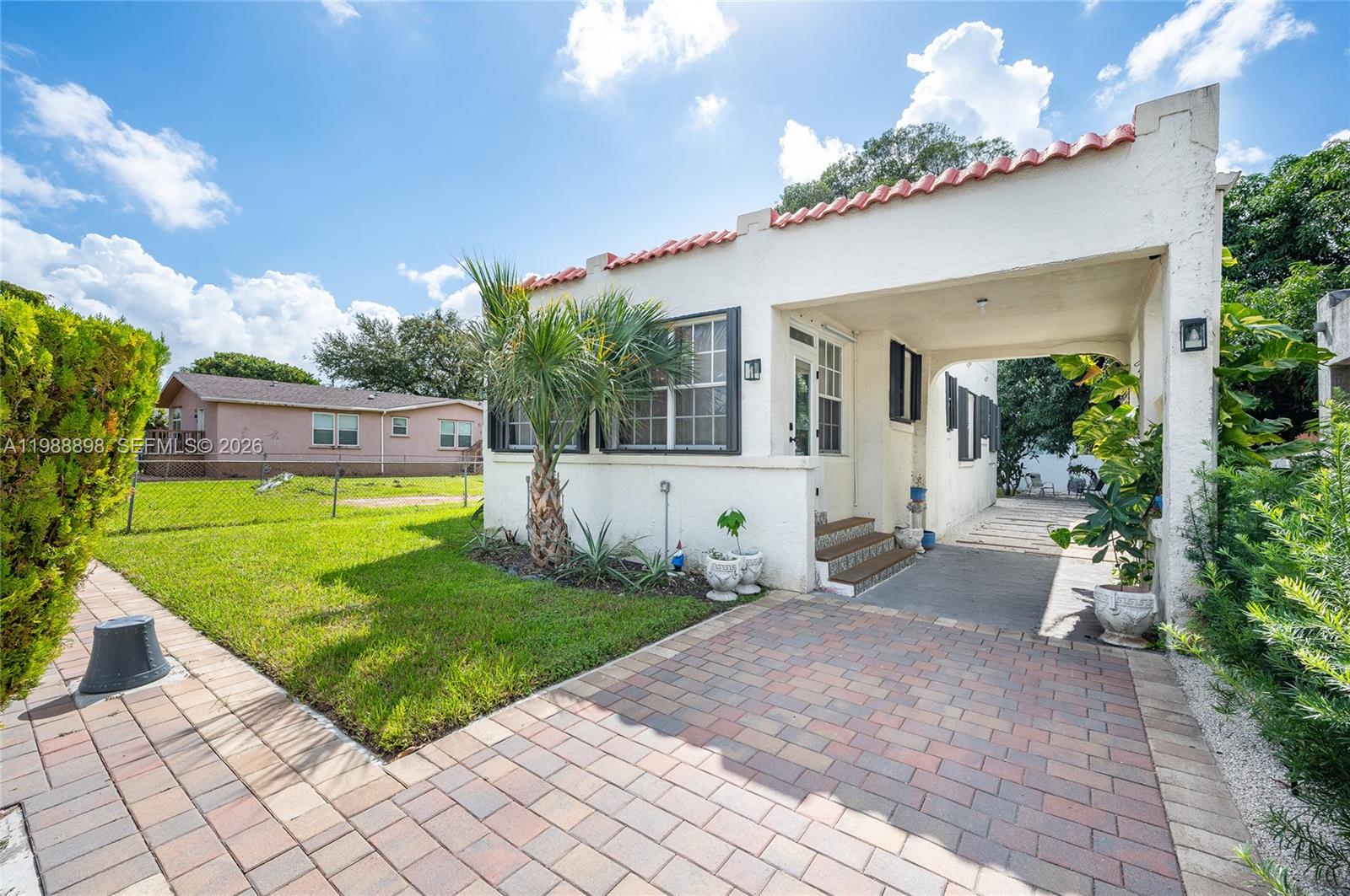 Miami's history lovingly and meticulously reimagined. This beautifully restored 1936 Spanish home blends timeless charm with modern comfort across 1,316 sq ft on a gated 4,800 sq ft lot. Sun-filled living with arched entries and a statement fireplace leads to a stunning kitchen with white cabinetry, bamboo counters, and blue Spanish tile backsplash. Two serene bedrooms and two remodeled baths feature impact entry door, new floors, and stylish finishes. Enjoy central A/C, laundry area, gated drive, covered carport, and a tropical yard with mango tree and 15×10 shed. Minutes from Wynwood, Design District, and Miami Beach—this home delivers character, comfort, and location. Turnkey, move-in ready, Yale smart lock & 65" Samsung TV included.