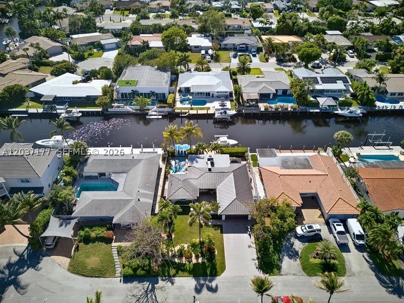 Beautifully updated & designed, this waterfront home offers the perfect balance of comfort, privacy & boating convenience. Ideally positioned near the mouth of the canal for quick access to open waterways, this exceptional property features 70 feet of waterfront, a private dock with dual electrical service, a 14,000-lb boat lift with remote controls, and a well-maintained seawall. Designed for both everyday living and entertaining, the open-concept floor plan centers around a spacious kitchen with granite countertops, custom wood cabinetry, stainless steel appliances, a modern hood, and generous bar seating. Bamboo flooring and custom window treatments add warmth and style throughout. The split-bedroom layout provides privacy, while the primary suite features a walk-in closet and dual-sink bath. Step outside to your own private retreat featuring a heated saltwater pool, pergola cabana, retractable awning, lush tropical landscaping, and custom outdoor lighting. Bedrooms offer convenient access to the patio and pool area, creating seamless indoor-outdoor living.
Recent upgrades include a new metal roof (2025), full impact windows and doors, a new 5-ton A/C system (2025), and updated electrical wiring. Additional highlights include a 2-car garage, paver driveway with parking for four additional vehicles, indoor laundry room, outdoor shower hookup, and a secure landscaped courtyard.
Located on a quiet street just minutes from Wilton Drive’s dining, shopping, and entertainment.