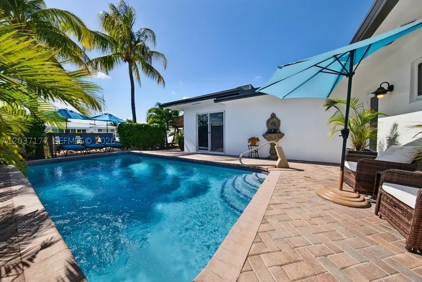 Beautifully updated & designed, this waterfront home offers the perfect balance of comfort, privacy & boating convenience. Ideally positioned near the mouth of the canal for quick access to open waterways, this exceptional property features 70 feet of waterfront, a private dock with dual electrical service, a 14,000-lb boat lift with remote controls, and a well-maintained seawall. Designed for both everyday living and entertaining, the open-concept floor plan centers around a spacious kitchen with granite countertops, custom wood cabinetry, stainless steel appliances, a modern hood, and generous bar seating. Bamboo flooring and custom window treatments add warmth and style throughout. The split-bedroom layout provides privacy, while the primary suite features a walk-in closet and dual-sink bath. Step outside to your own private retreat featuring a heated saltwater pool, pergola cabana, retractable awning, lush tropical landscaping, and custom outdoor lighting. Bedrooms offer convenient access to the patio and pool area, creating seamless indoor-outdoor living.
Recent upgrades include a new metal roof (2025), full impact windows and doors, a new 5-ton A/C system (2025), and updated electrical wiring. Additional highlights include a 2-car garage, paver driveway with parking for four additional vehicles, indoor laundry room, outdoor shower hookup, and a secure landscaped courtyard.
Located on a quiet street just minutes from Wilton Drive’s dining, shopping, and entertainment.
