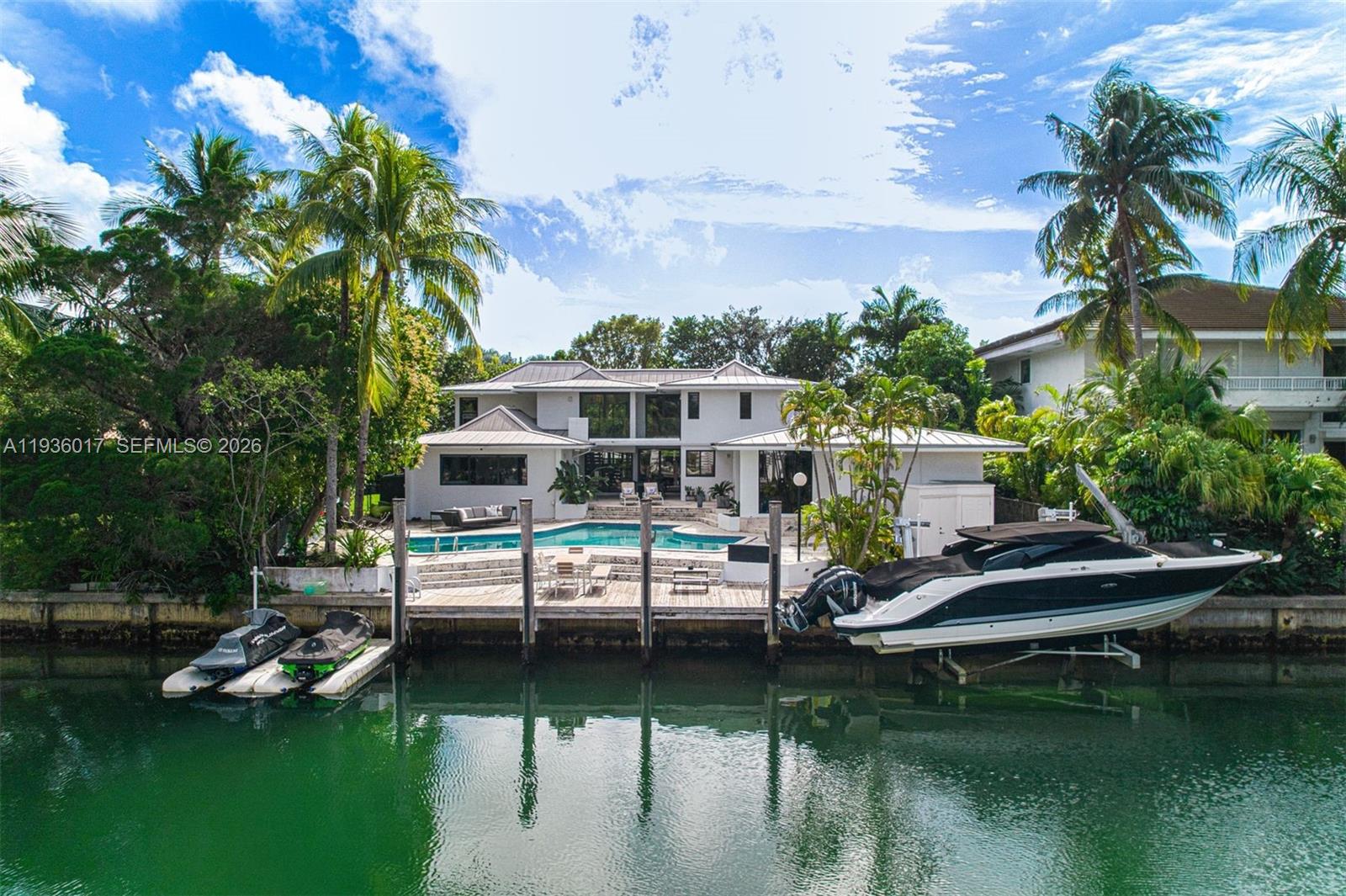 Designed for those who value privacy, space, and a true connection to the water, this exceptional waterfront residence offers a rare boater’s retreat and a warm, inviting setting for family living. Tucked away on a quiet street and set on an expansive nearly 14,000-square-foot lot, the home impresses from the moment you arrive with its generous front yard and gated entry, offering both presence and privacy. Inside, a bright two-story layout unfolds with an open, airy feel, thoughtfully designed for both everyday comfort entertaining. The residence features five bedrooms, four full bathrooms, plus a cabana bath, all flowing seamlessly enhanced by abundant natural light and tranquil water views. Renovated in 2019, the home includes impact windows and doors, a beautifully updated kitchen and appliances, lighting throughout, gas generator, and a pool heater and chiller for year-round enjoyment. The outdoor living experience is truly exceptional…enjoy direct water access with a private dock, boat lift, and two dry jet-ski docks, allowing you to step straight from your backyard to open water and fully embrace the waterfront lifestyle. A detached, enclosed two-car garage adds versatility, while the gated property offers abundant parking for up to six vehicles, a rare and valuable amenity in Key Biscayne. Homes of this caliber which offer privacy, boating infrastructure, generous land, and modern upgrades are increasingly rare and best appreciated in person.