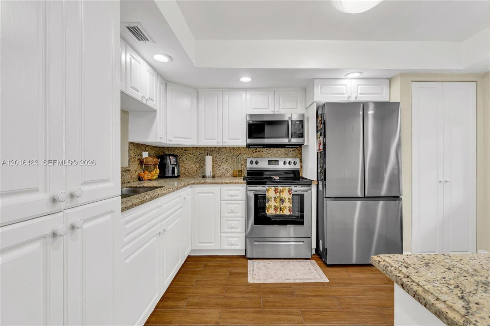 Tastefully updated condo with tranquil lake views, scenic walking and jogging paths, and inviting outdoor sitting areas to enjoy the community atmosphere. Residents have access to a variety of amenities including a fitness center, social and multipurpose rooms, billiards, theater room, arts and crafts space, card rooms, jacuzzi, saunas, heated swimming pool, tennis courts, racquetball courts, and shuffleboard.
Ideally situated close to shopping centers, restaurants, major highways, and medical facilities. This residence features renovated kitchen and bathrooms with granite surfaces, newer stainless-steel appliances, tile floors throughout, an updated A/C unit, and a tankless water heater. The private balcony overlooks the lake, creating a relaxing outdoor retreat. Accordion hurricane shutters are also included for added convenience and protection.