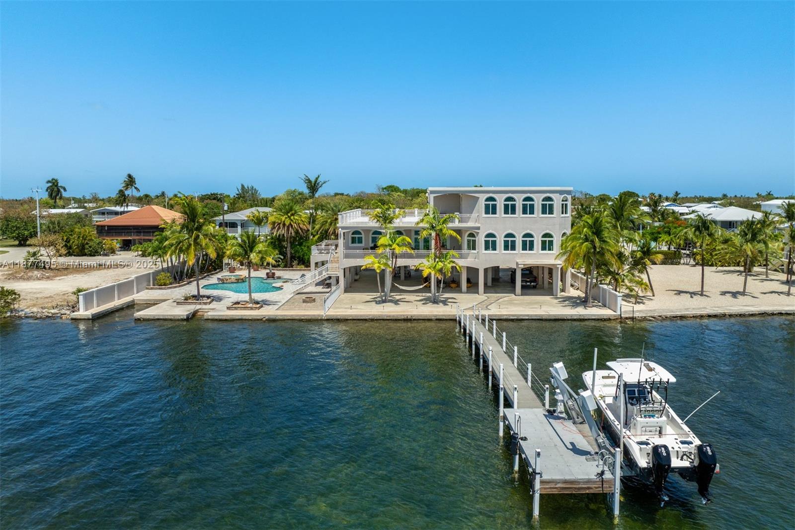 Escape to “The Castle”, a luxurious gated Gulf-front estate spanning 1.14 acres on Big Pine Key. Built in 2014 with poured concrete, impact windows/doors, elevator, and generator, this 4,600+ sq. ft. masterpiece offers 3 bedrooms, 3 baths, and breathtaking Gulf views. Boaters enjoy 235’ of dockage: 140’ protected canal dock with lift, ramp, and slip, plus 95’ open-water pier dock with lift and seawall. Inside, a chef’s kitchen with 10.5’ island, dual sinks, Jenn-Air gas range, and wood cabinetry flows to a grand family room, theater, and rooftop deck. The top-floor primary suite boasts water views, office, lounge, spa bath, and custom closet. Outside, a resort-style pool with spa, heater/chiller, and LED lighting completes this rare Florida Keys retreat.
