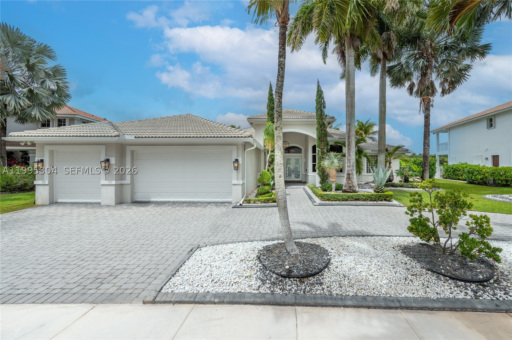 Beautiful one-story home located in the desirable north section of Victoria Isle within Weston Hills, known for its oversized lots and enhanced privacy. Situated on a 16,000 sq ft lot with serene lake views, this residence offers 5 bedrooms and 3.5 bathrooms and just under 4,000 sq ft of living space, with tile flooring throughout the main living areas and updated wood floors in the bedrooms. High ceilings create a bright and open feel. The modern white kitchen features granite countertops, stainless steel appliances, and a functional layout open to the living areas. Bathrooms are well maintained and tastefully appointed. The primary suite includes a sitting area, two walk-in closets, and an oversized bathroom featuring dual sinks, an oversized shower, and Jacuzzi. The home features curtains and blackout shades in all bedrooms, along with wood plantation shutters in the formal dining room and office. Motorize blinds in family room area. Enjoy outdoor living with a private pool, lake views, a beautifully landscaped yard, and a circular driveway. The entire backyard is finished with gray marble, offering a sleek, low-maintenance space. Recently smoothed walls and ceilings throughout, and freshly painted interior and exterior Additional features include a 3-car garage, 2 A/C units (2023-2024) equipped with a Nest system. Roof (2026) upgraded to flat tile. New variable speed pool pump (2025). A true gem in the prestigious Country Club of Weston.