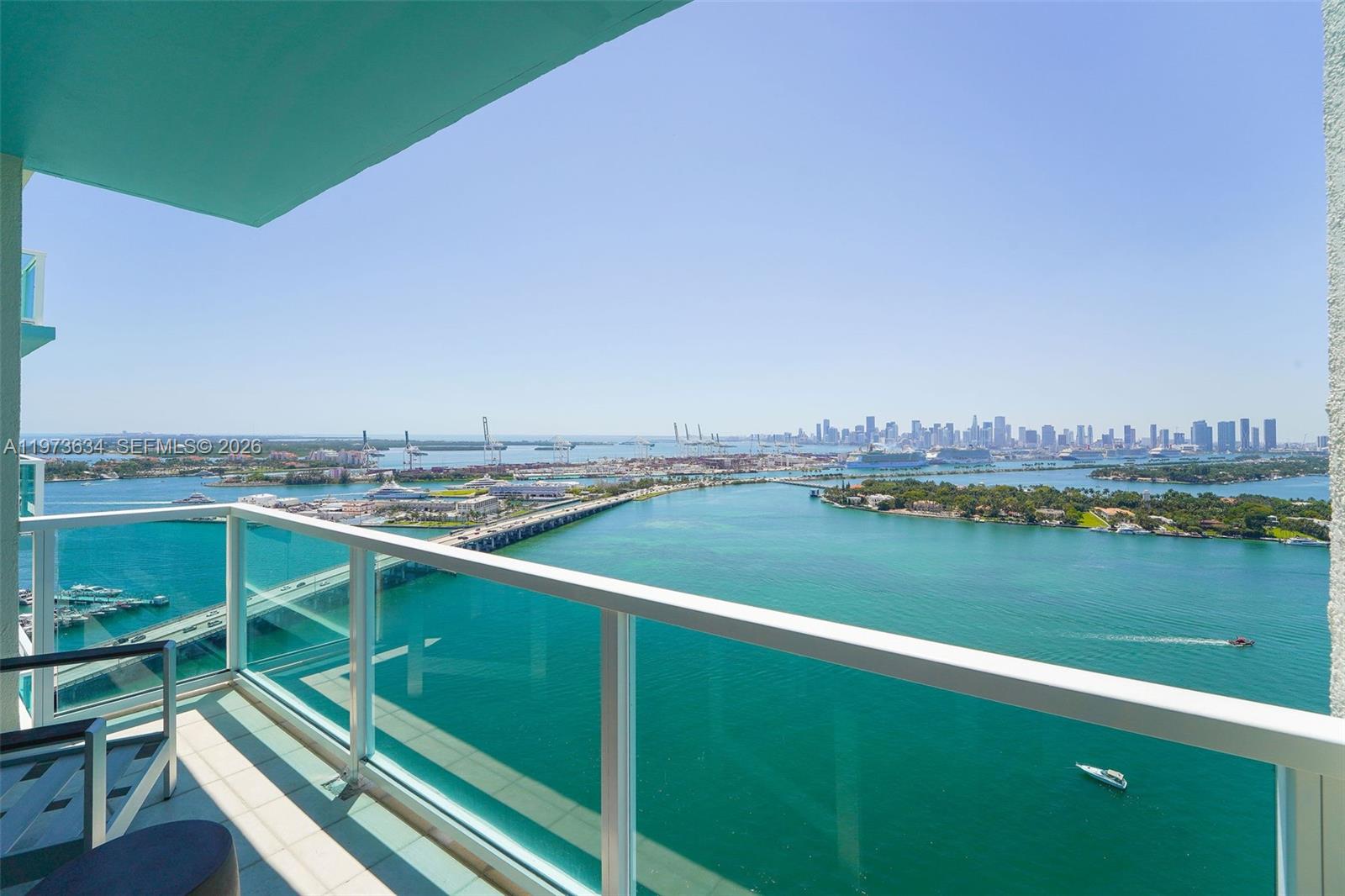 Penthouse-level residence at The Floridian with sweeping direct bay and skyline views framed by floor-to-ceiling glass. Higher ceilings unique to the PH level enhance the light and open feel, while three private balconies extend the living space outdoors and capture stunning sunsets. Marble flooring runs throughout the residence. The kitchen features a waterfall island, built-in wine cooler, and stainless steel appliances. The primary suite offers a spa-style bath and an oversized custom closet. Two parking spaces included.Full-service bayfront building with two pools, hot tub, tennis court, gym, market, business center, marina, 24-hour security and valet. Prime West Avenue location surrounded by shopping, restaurants, and minutes to Lincoln Road and the beach.
