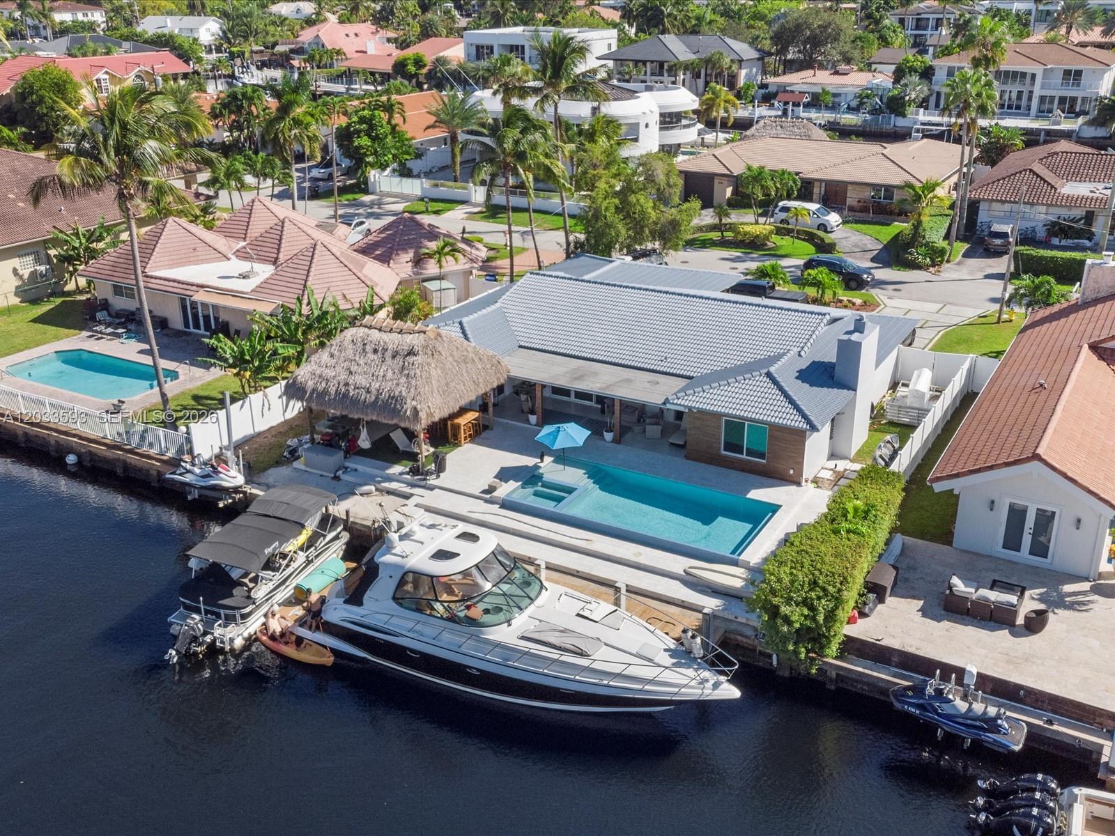 Experience luxury waterfront living in this contemporary residence. This exceptional home features a spacious modern custom kitchen, impact-resistant windows and doors, and a heated pool with an amazing hot tub, creating the perfect setting for relaxation and entertaining.
The primary suite offers direct water views and includes a luxurious oversized bathroom with a separate steam shower and spa-like amenities.
Boating enthusiasts will appreciate the private 80-foot dock with no fixed bridges and direct ocean access.
Step outside to your own private oasis in the oversized backyard, complete with a Jacuzzi, BBQ area, pizza oven, outdoor kitchen, and comfortable lounge space beneath a stunning oversized tiki hut overlooking the canal.
Additional features include a two-car garage and an unbeatable location just moments from the beach, Bal Harbour Shops, and Aventura Mall.