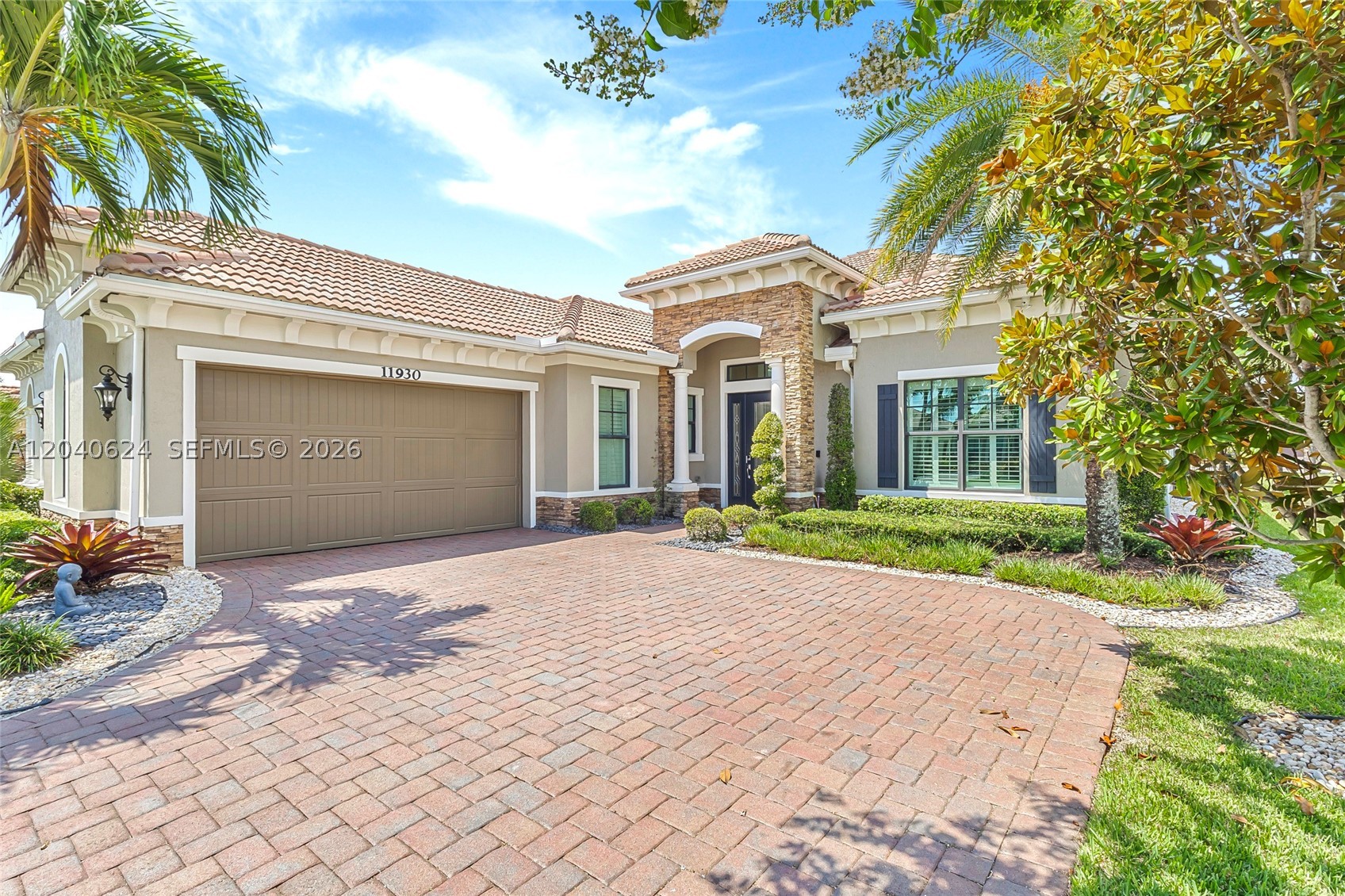 Stunning home at the Four Seasons at Parkland. 55+ Living at Its Finest! Situated on a private corner lot, this impeccably maintained 2BR/2.5BA home with a versatile DEN is loaded with upgrades. The FLEXIBLE DEN is ideal as a guest room, home office, hobby room, or potential 3rd bedroom. The open-concept floor plan features oversized polished porcelain tile flooring, soaring volume and tray ceilings, crown molding, plantation shutters, and designer lighting throughout. The gourmet kitchen boasts custom cabinetry, gas cooktop, built-in wall oven, stainless steel appliances, oversized island, and a custom wet bar perfect for entertaining. Enjoy a private owner’s retreat with a spacious primary suite and spa-inspired bath featuring dual vanities, a walk-in shower, soaking tub, and expansive closet space. Additional highlights include separate laundry and mud rooms, abundant storage, and a 2.5-car garage with epoxy flooring, custom cabinetry, overhead storage, and an EV/hybrid charging station. Relax outdoors on the extended travertine lanai with remote-controlled screens, lush landscaping, and exterior accent lighting surrounding the home, creating a beautiful ambiance day and night.