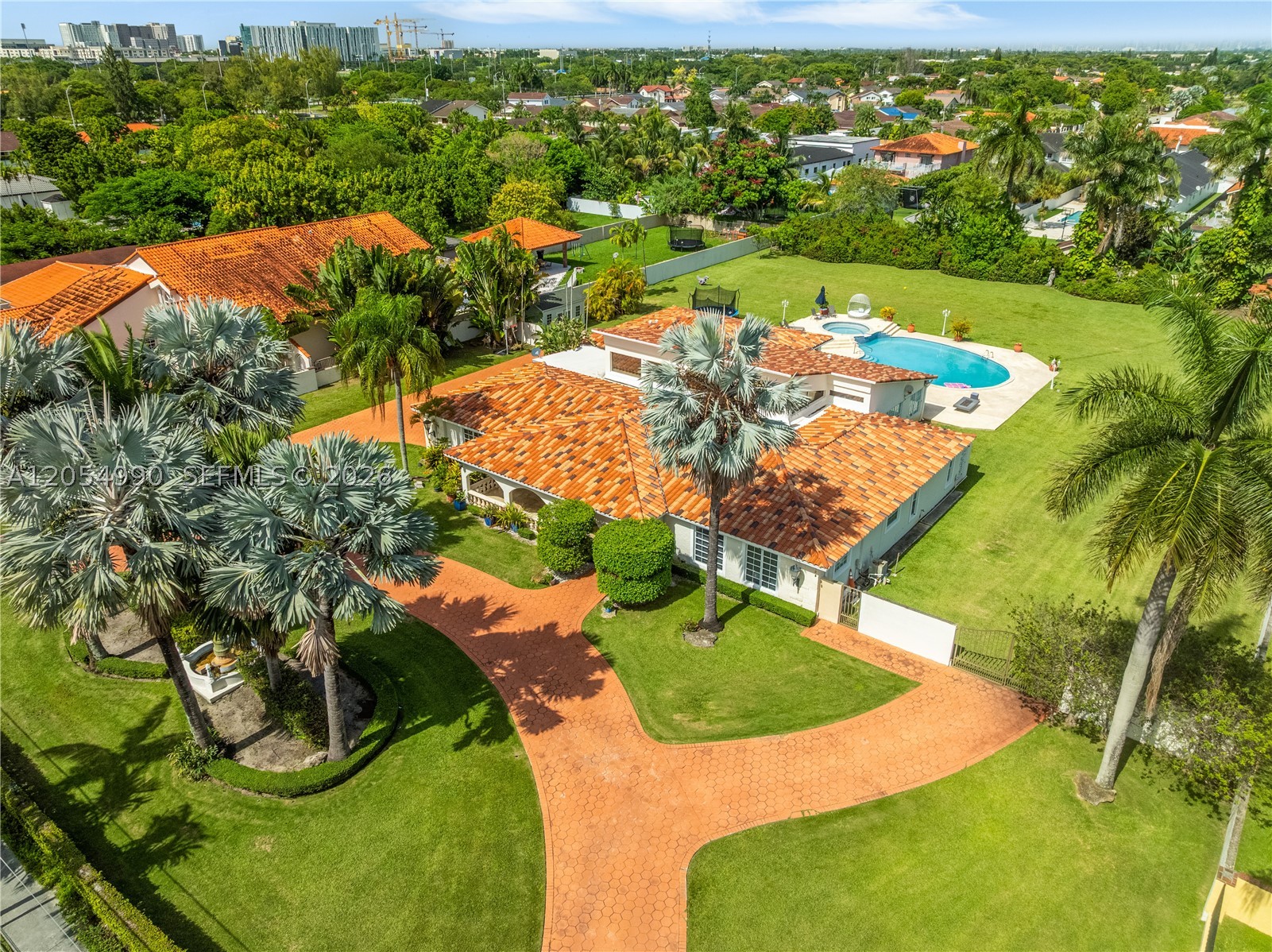 Welcome to your Mediterranean dreamscape, a unique gated estate offering over 4,700 SF of living space on a private 1.25-acre lot. This expansive one-story residence offers 5 bedrooms, 5 baths, soaring ceilings, marble floors, abundant natural light, formal living and dining areas, a spacious family room, and an oversized eat-in kitchen. The private primary suite includes dual walk-in closets and a spa-inspired bath. The outdoors boasts a resort-style pool, a covered patio with a summer kitchen, a children's playground, a storage shed, two entrances with electric gates, a circular driveway, and a two-car garage, perfectly designed for entertaining and everyday living.