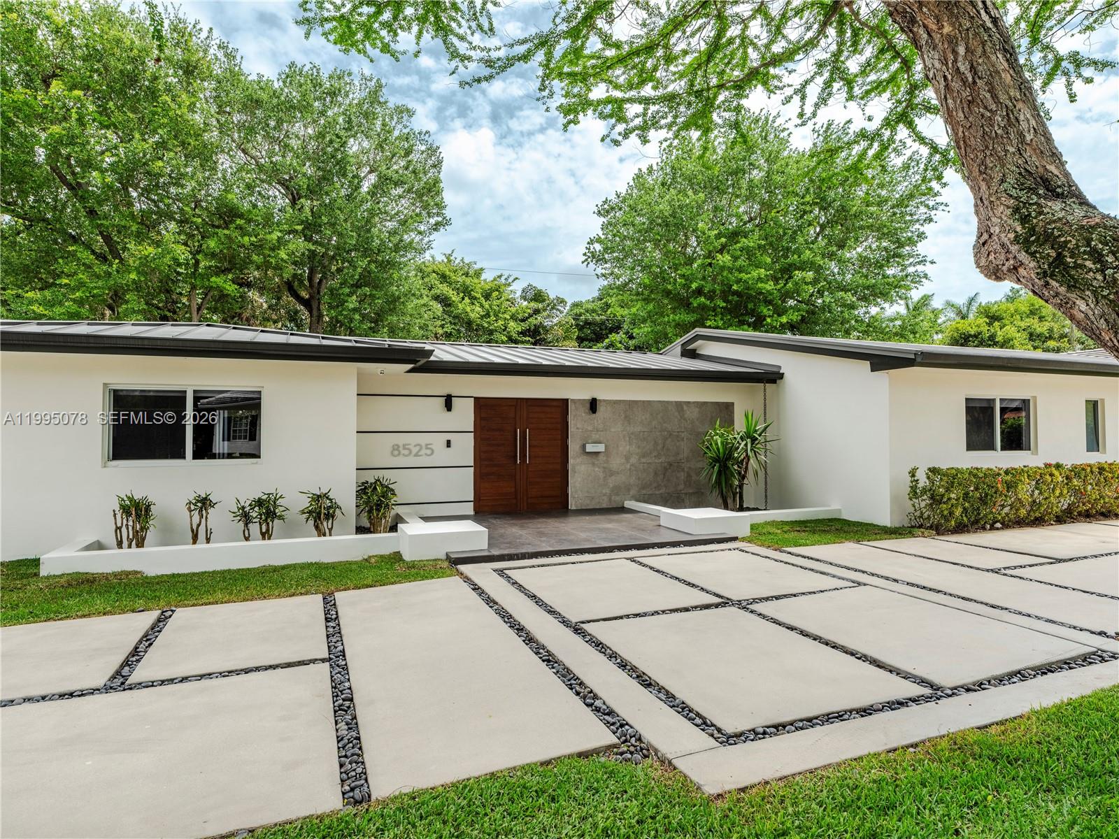 Completely rebuilt in 2017 (construction permits available), this exceptional residence provides 3374 SF of indoor & covered outdoor areas. Every major system and finish has been thoughtfully upgraded, creating a turnkey home designed for both comfort and style. The renovation included electrical systems (buried utility lines), updated plumbing (removed cast iron pipes). Interior and exterior improvements include reconfigured hurricane resistant windows and doors, framing & drywall, interior doors, bathrooms, flooring. The kitchen and baths showcase modern cabinetry, countertops, and appliances. A metal roof with gutters throughout, while mechanical systems were upgraded to include two-zone air conditioning, ducts, and tankless water heaters for optimal efficiency and comfort.

Designed with outdoor living in mind, the property features a resort-style heated and cooled pool, along with a custom pergola complete with ceiling fans and a built-in sound system—perfect for entertaining year-round. The lush landscaping includes a fully irrigated yard with three sprinkler zones, a dedicated children’s play area, and a mature podocarpus hedge providing privacy and greenery. Five mature trees, including three stately oaks, further enhance the property’s natural beauty and shade. This is a rare opportunity to own a home, on a 15,600 SF lot, that offers the character of a classic build with the systems, finishes, and lifestyle of a much newer residence.