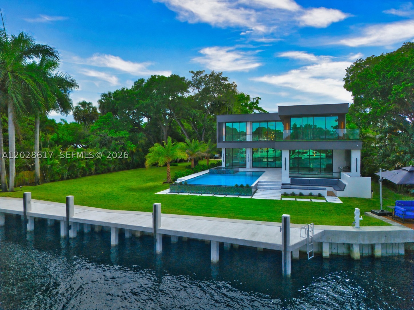 FULLY GATED COMPOUND — Brand new 2026 waterfront estate set on a sprawling ¾-acre (33,600 SF) private double lot measuring approximately 250 ft. deep by 134 ft. wide, with 134 ft of prime deeded wide-river frontage and breathtaking downtown skyline views. Offering just under 6,700 SF under AC and nearly 9,800 total SF, this exceptional residence features 6 bedrooms, 6 en-suite baths, 2 half baths, and integrated Lutron and Control4 smart home systems. Designed for grand-scale luxury living, the estate includes a private movie theater, commercial elevator, steam room, and a resort-style saltwater pool and spa. The expansive grounds provide ample space for an additional residence, guest retreat, or amenities such as a pickleball or tennis court, mini golf course, or other recreational features—creating a true private waterfront compound. The 100+ foot driveway leads to a 3-car garage designed to accommodate up to 6 vehicles with lifts, Additional side alley access allows discreet parking for an RV, motor coach, or additional watercraft. Outdoor living is elevated with a fully equipped summer kitchen, gas fire pit lounge, and a spectacular 23' x 48' saltwater pool with an 8' x 12' spa.

A brand-new seawall and concrete dock can accommodate a 100-foot yacht plus an additional 25–30-foot vessel, or a mega yacht up to 125 feet. Surrounded by mature trees and lush tropical landscaping, this exceptionally private estate offers a rare and unparalleled South Florida luxury offering.